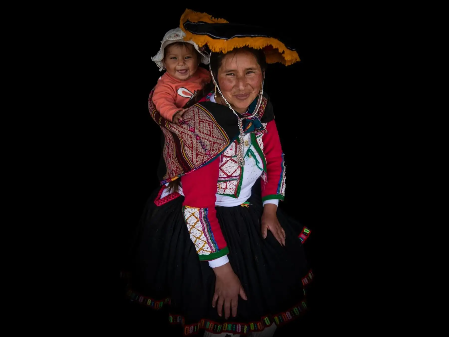 Ana Mamani Calero, viste chaquetas con tejidos de colores, conocidas como almilla, y lleva una manta llamada Lliclla. Sostiene a su hija, Emma Luana Quispe Mamani. Foto: ANDINA/Carlos Lezama Villantoy