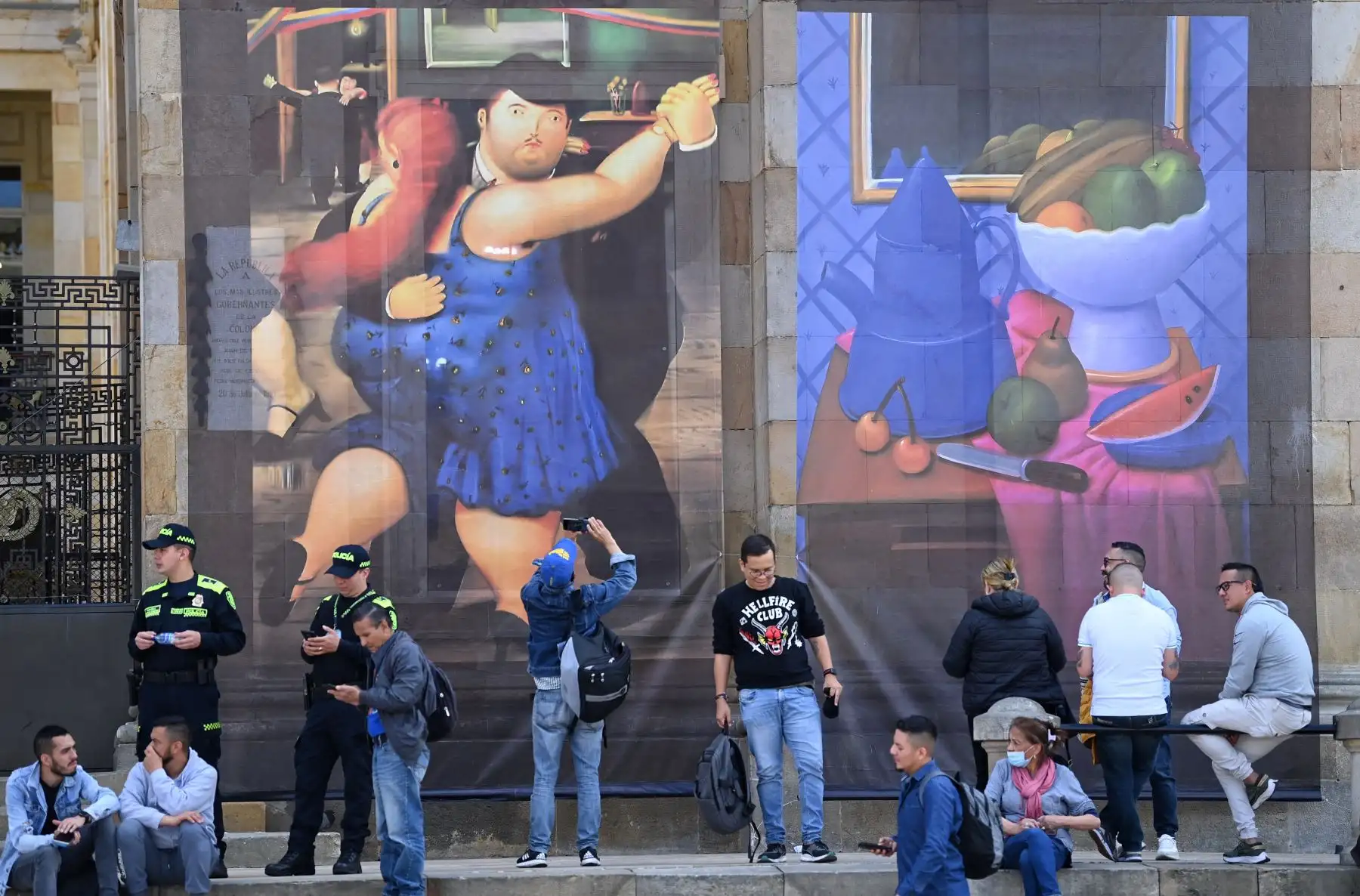 Pinturas del pintor y escultor colombiano Fernando Botero, quien murió a los 91 años el 15 de septiembre, se exhiben en la fachada del Congreso en Bogotá mientras sus restos descansan en la capilla funeraria ubicada en el edificio.
Foto: AFP