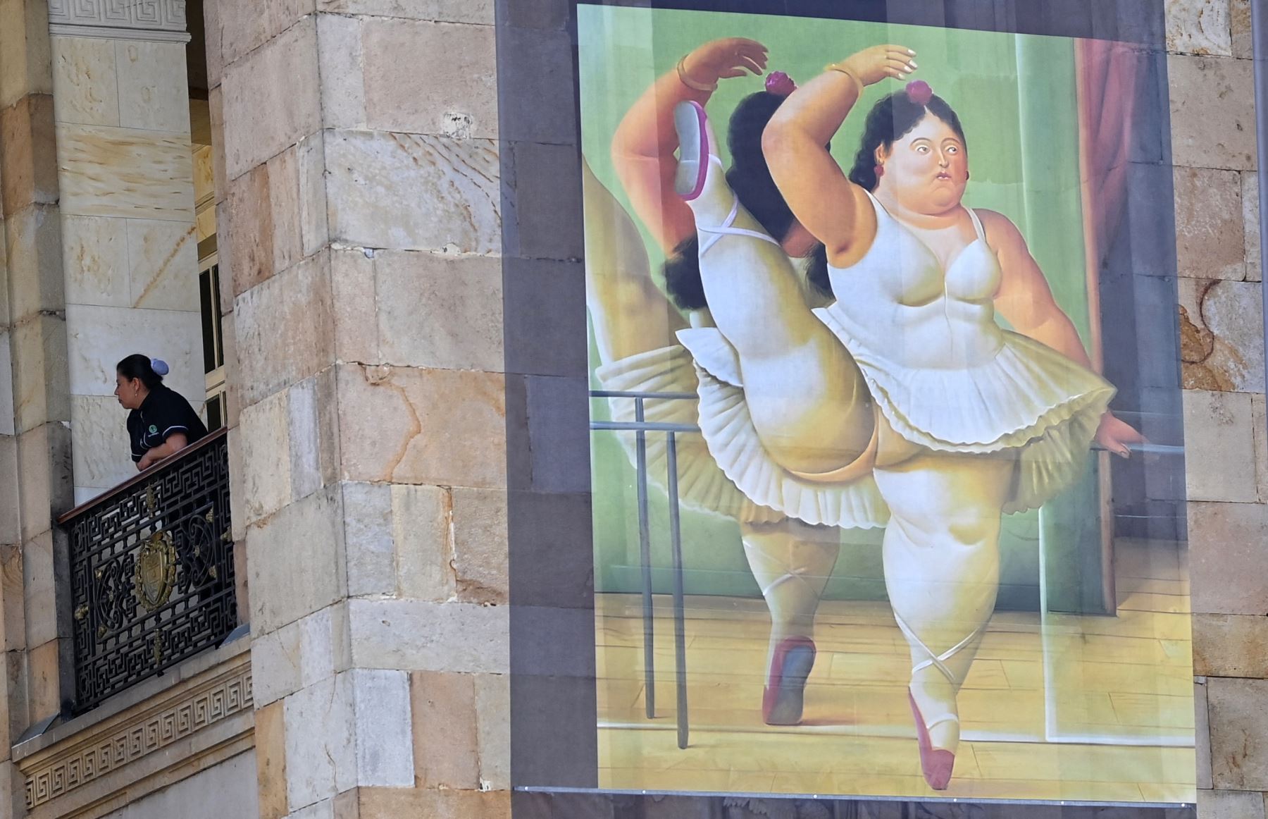Una pintura del pintor y escultor colombiano Fernando Botero, quien murió a los 91 años el 15 de septiembre, se exhibe en la fachada del Congreso en Bogotá mientras sus restos descansan en la capilla funeraria ubicada en el edificio.
Foto: AFP