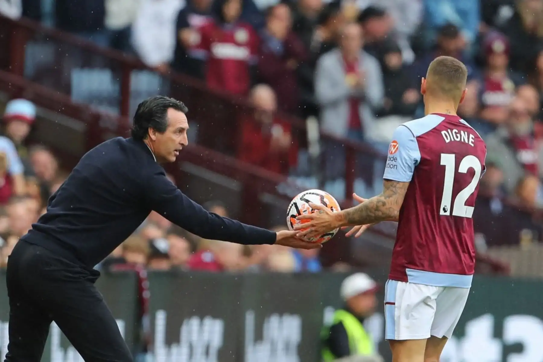 El entrenador español de ston Villa, Unai Emery, le da un balón al defensor francés de Aston Villa, Lucas Digne, durante el partido de fútbol de la Premier League inglesa entre Aston Villa y Brighton y Hove Albion en Villa Park en Birmingham, centro de Inglaterra. Foto: AFP