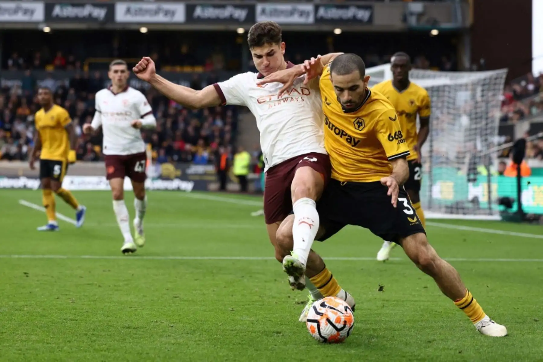 El delantero argentino del Manchester City Julian Alvarez, lucha por el balón con el defensor francés del Wolverhampton Wanderers Rayan Ait-Nouri durante el partido de fútbol de la Liga Premier inglesa entre Wolverhampton Wanderers y Manchester City en el estadio Molineux de Wolverhampton, en el centro de Inglaterra. Foto: AFP