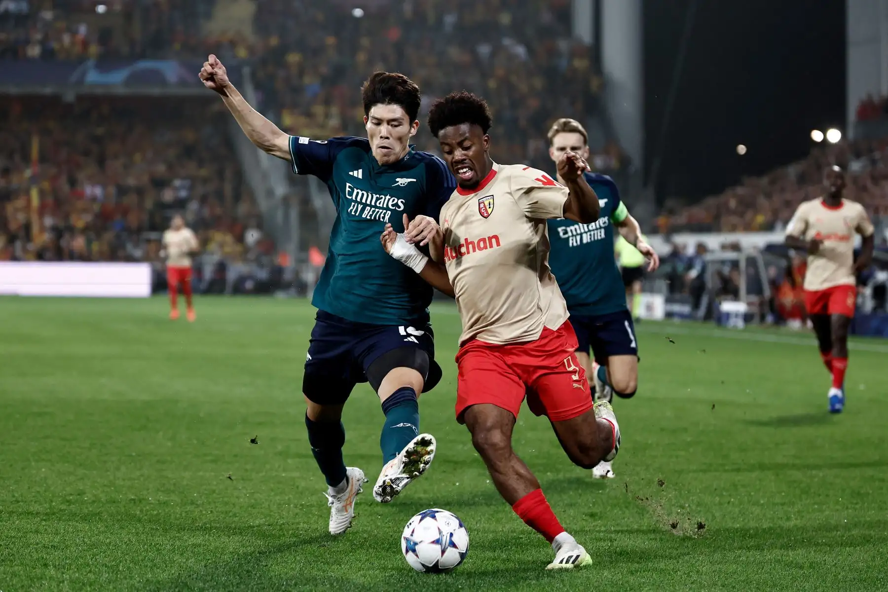 El delantero francés de Lens, Elye Wahi lucha por el balón con el defensor japonés del Arsenal, Takehiro Tomiyasu durante el partido de fútbol de ida del grupo B de la Liga de Campeones de la UEFA entre el RC Lens y el Arsenal FC .
Foto: AFP