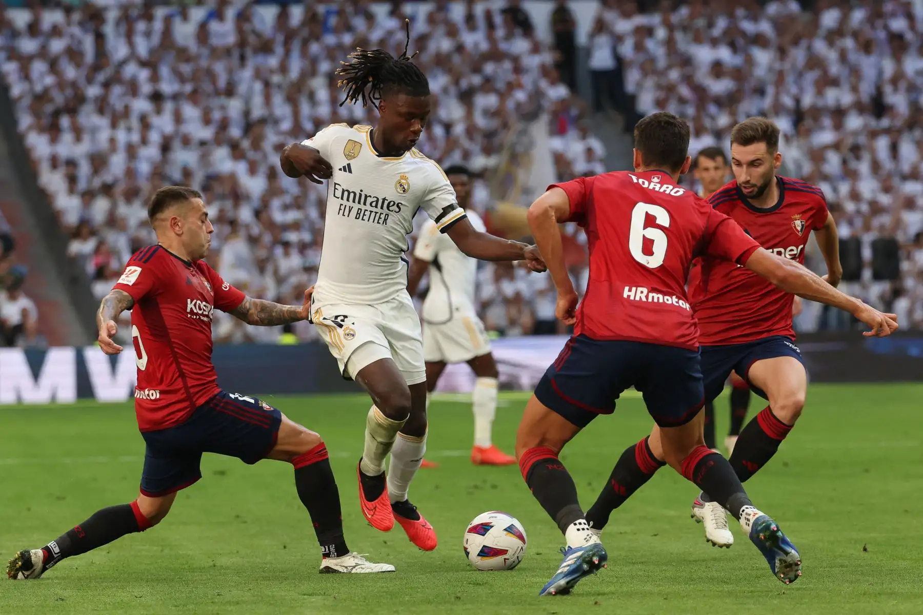 El centrocampista francés del Real Madrid Eduardo Camavinga  lucha por el balón con el defensor español de Osasuna  Rubén Peña  y el centrocampista español de Osasuna Lucas Torro durante el partido de fútbol de la liga española entre el Real Madrid CF y el CA Osasuna en el Santiago Estadio Bernabéu de Madrid. Foto: ANDINA/ AFP