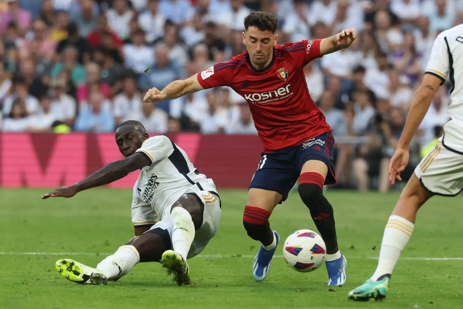El defensor francés del Real Madrid Ferland Mendy lucha por el balón con el delantero español de Osasuna Kike Barja durante el partido de fútbol de la liga española entre el Real Madrid CF y el CA Osasuna en el estadio Santiago Bernabeu de Madrid. Foto: ANDINA/ AFP