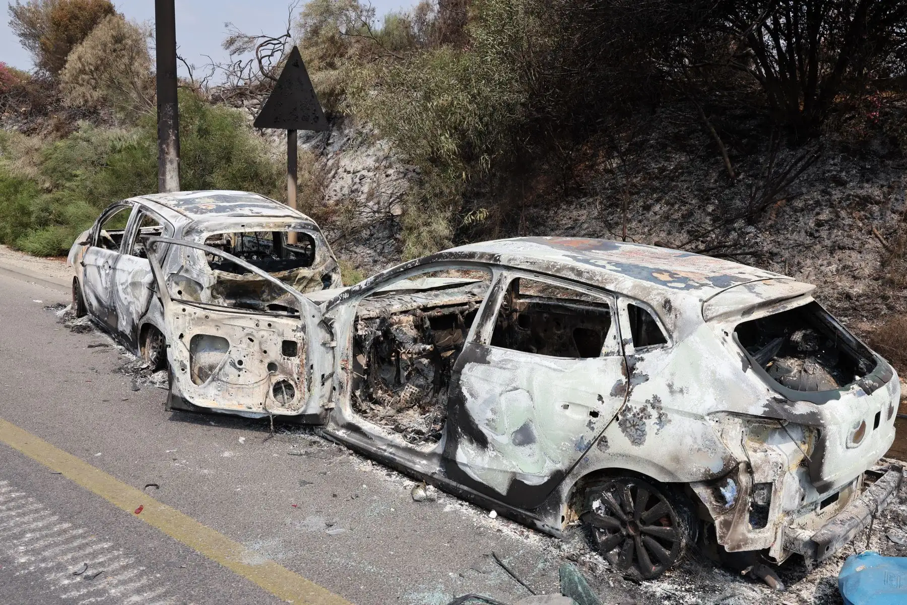 Coches quemados durante una infiltración de militantes palestinos de la Franja de Gaza, se encuentran al costado de una carretera un día después del ataque, cerca de la ciudad sureña de Sderot.
Foto: AFP