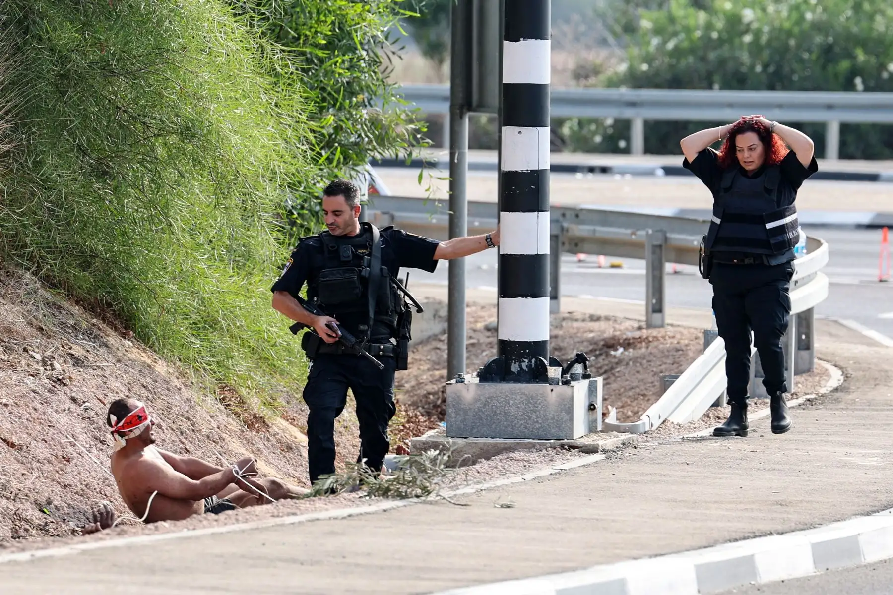 Un prisionero palestino con los ojos vendados habla con un miembro de las fuerzas de seguridad israelíes en la frontera con Gaza, cerca de la ciudad de Ashkelon, en el sur de Israel.
Foto: AFP