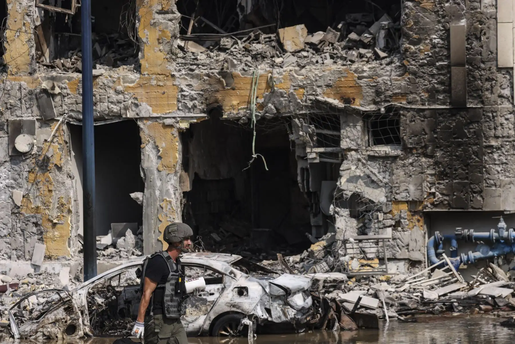 Un miembro de las fuerzas de seguridad pasa junto a una comisaría de policía israelí en Sderot después de que fuera dañada durante los combates para desalojar a los militantes de Hamás que estaban estacionados en su interior.
Foto: AFP