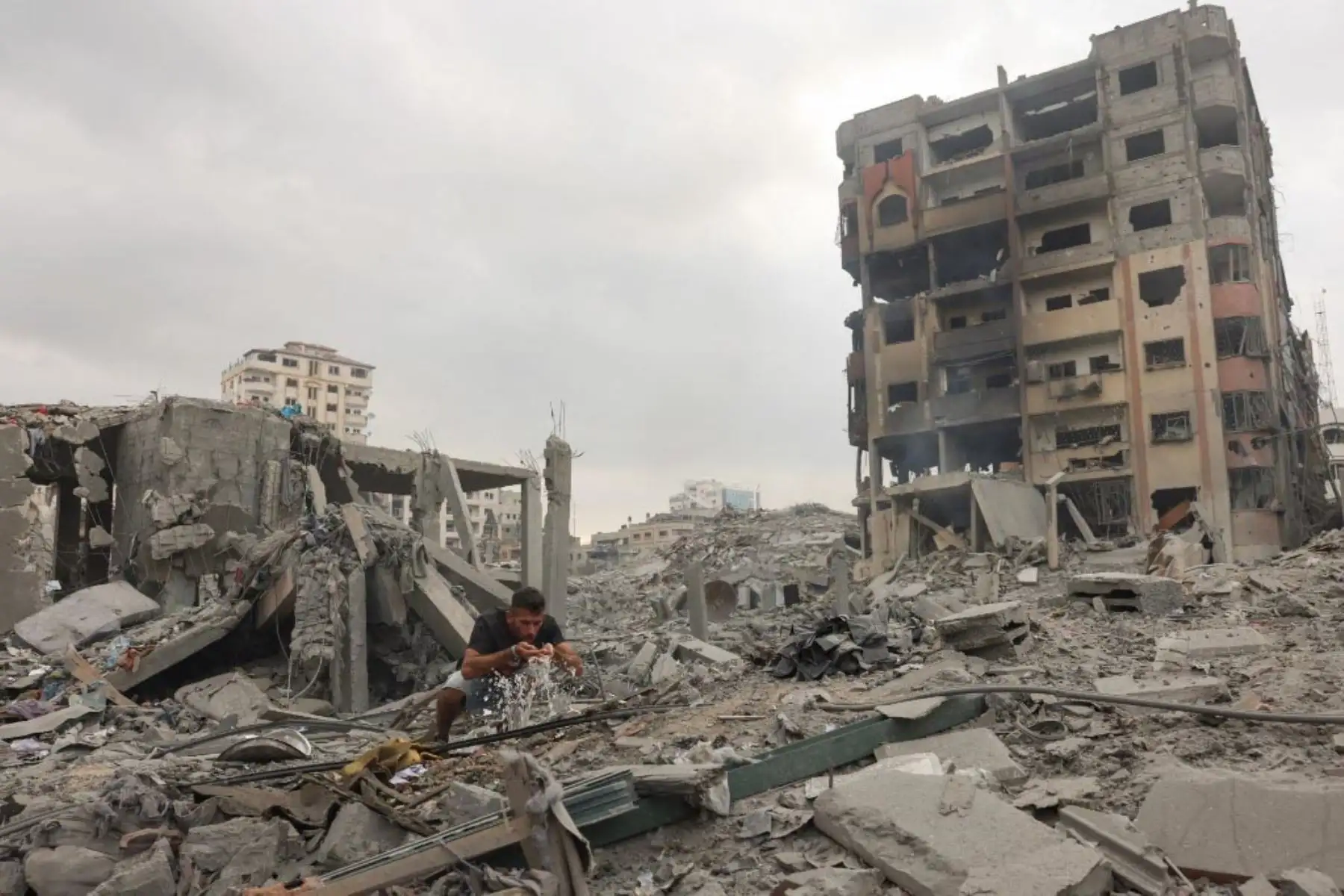 Palestinos caminan por una calle devastada tras los ataques aéreos israelíes en la ciudad de Gaza. Foto: AFP