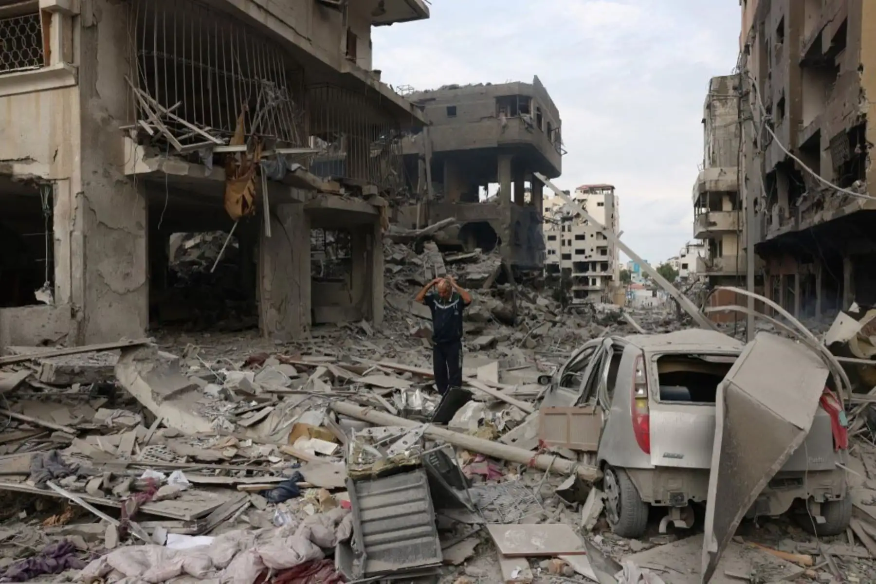 Palestinos caminan por una calle devastada tras los ataques aéreos israelíes en la ciudad de Gaza. Foto: AFP