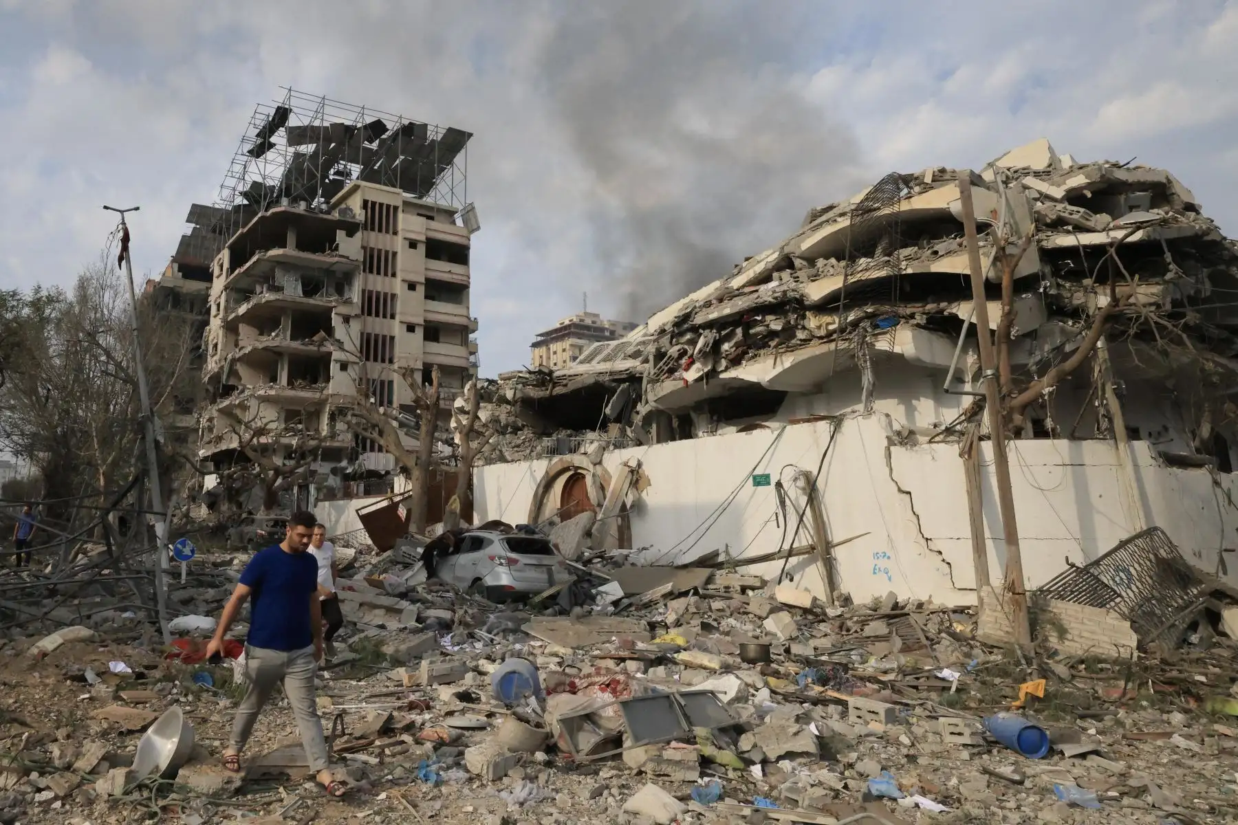 Palestinos caminan por una calle devastada tras los ataques aéreos israelíes en la ciudad de Gaza. Foto: AFP