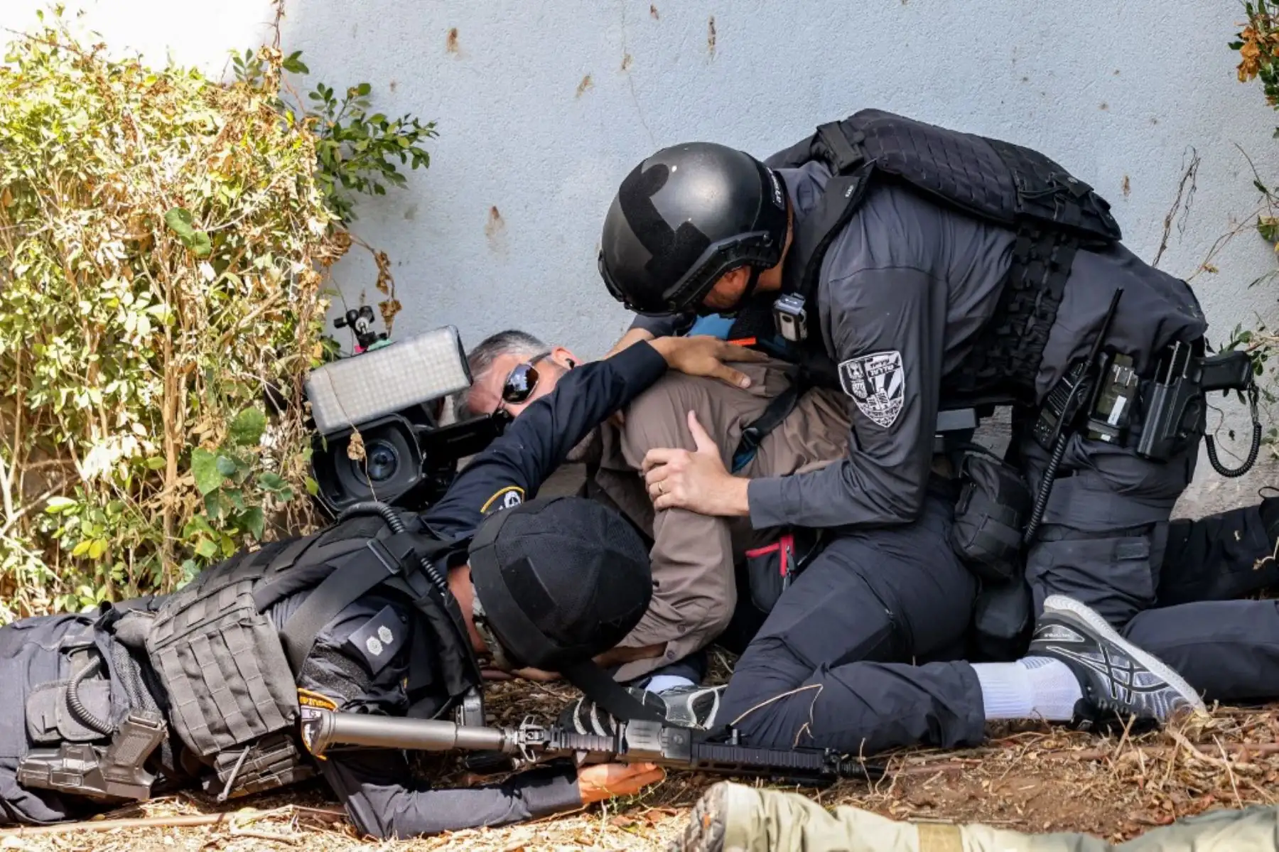 La policía y las fuerzas de seguridad israelíes ayudan a un periodista a cubrirse durante una alerta por un ataque con cohetes en la ciudad de Sderot, en el sur de Israel, cerca de la frontera con Gaza. Foto: AFP