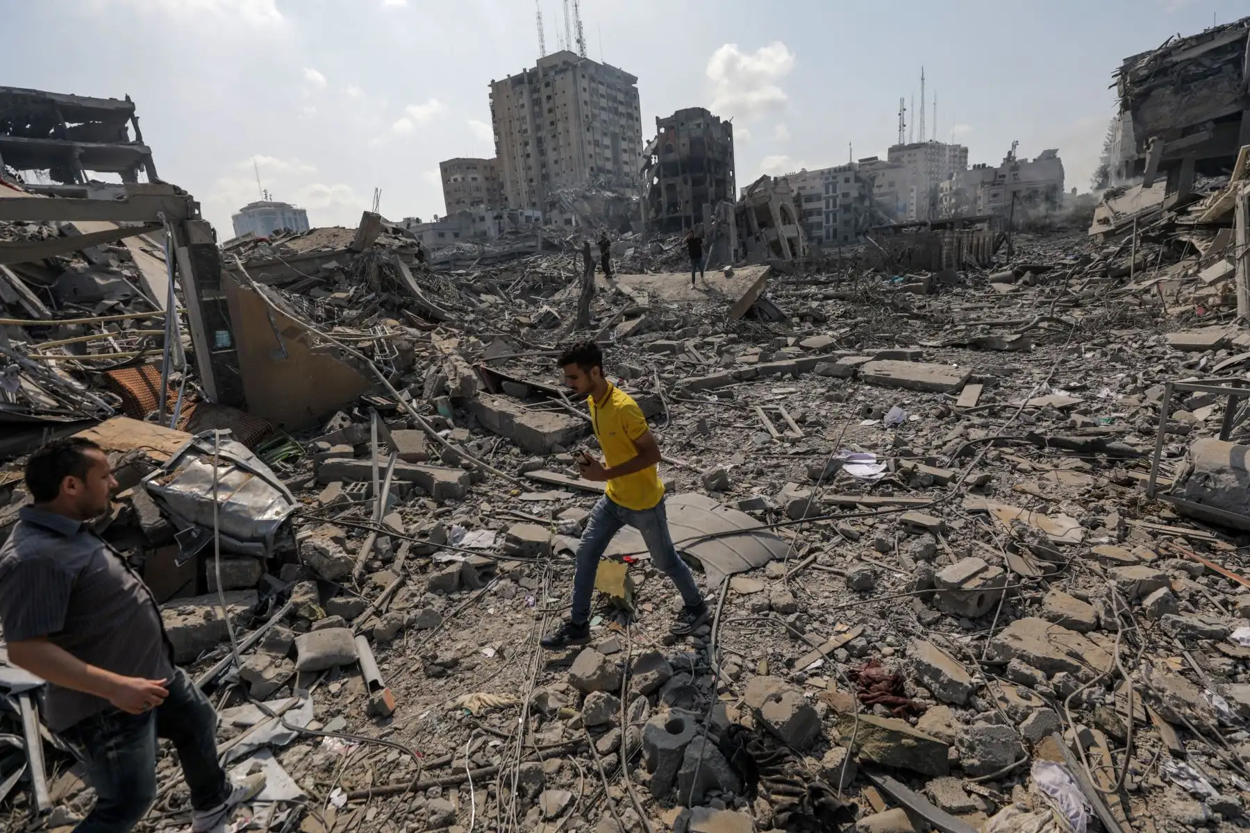 Palestinos caminan entre los escombros tras un ataque a la zona de Al-Ramal, tras un ataque israelí, este martes en la Ciudad de Gaza. Más de 700 personas han muerto y alrededor de 4.000 han resultado heridas después de que Israel comenzara a bombardear Gaza como respuesta al ataque en suelo israelí del grupo islamista Hamas, según datos ofericos por las autoridades palestinas. En total más de 3000 personas han muerto en esta escalada de violencia desde el 7 de octubre, según fuentes palestinas e israelíes.