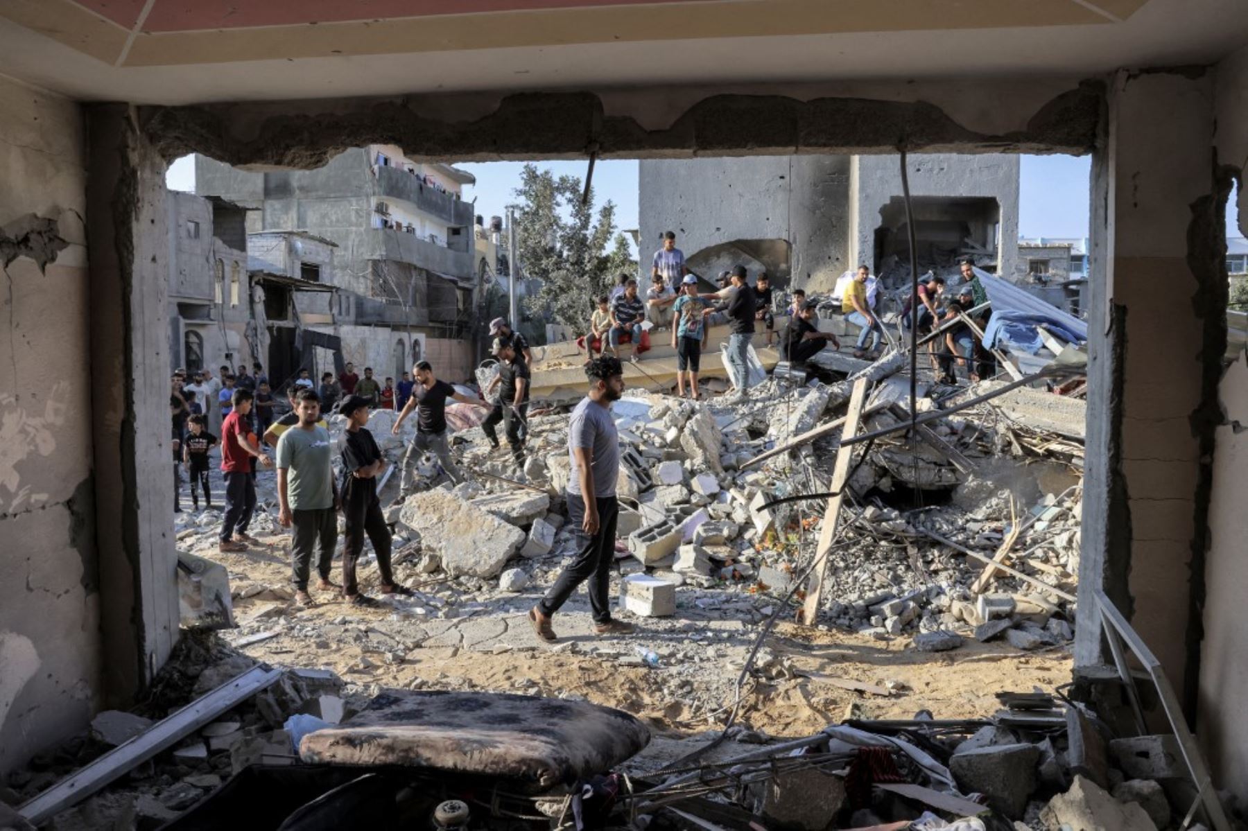 La gente se reúne junto a los escombros de un edificio tras un ataque aéreo israelí en Rafah, en el sur de la Franja de Gaza. Los ataques israelíes contra el enclave costero han matado a más de 1.530 personas desde el sábado, incluidos 500 niños, según el Ministerio de Salud de Gaza. Foto: AFP