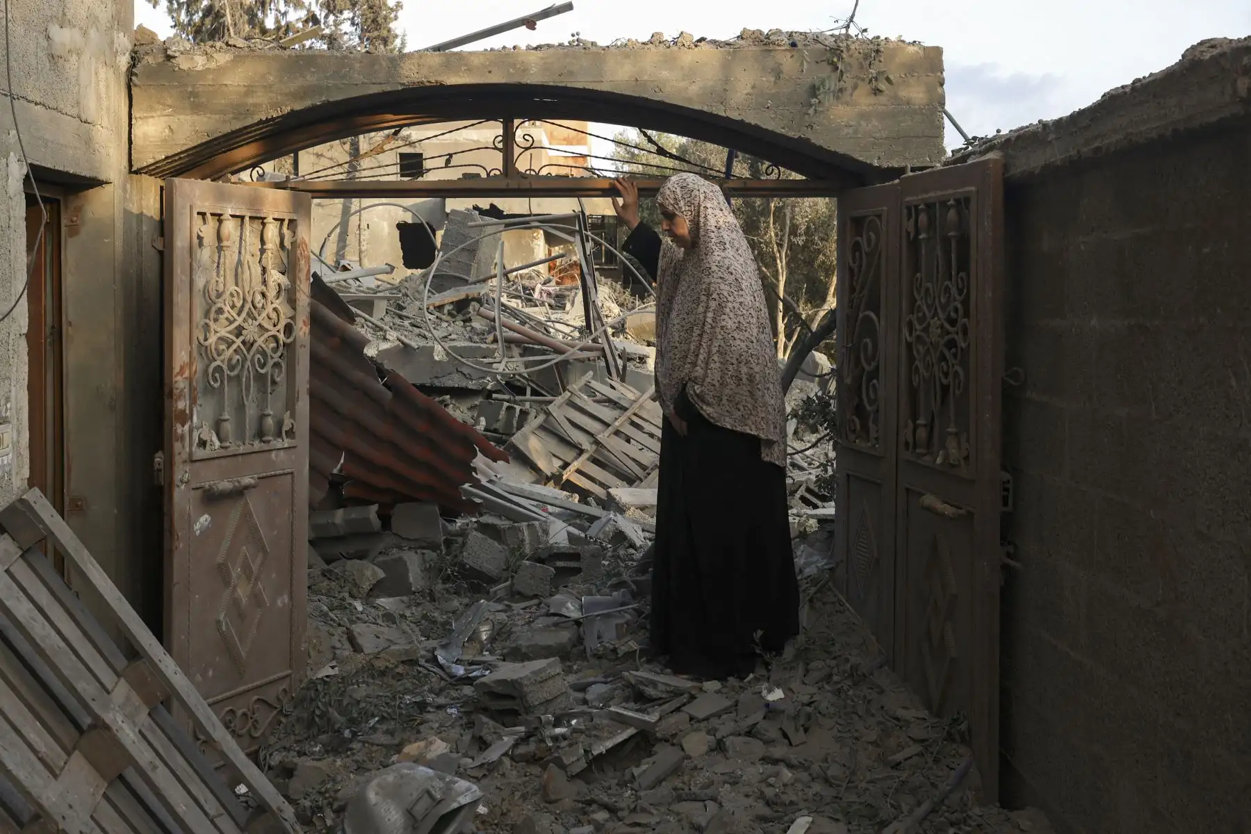 Una mujer inspecciona los daños sufridos por su casa tras los ataques israelíes contra el campamento de Rafah, en el sur de la Franja de Gaza.
Foto: AFP