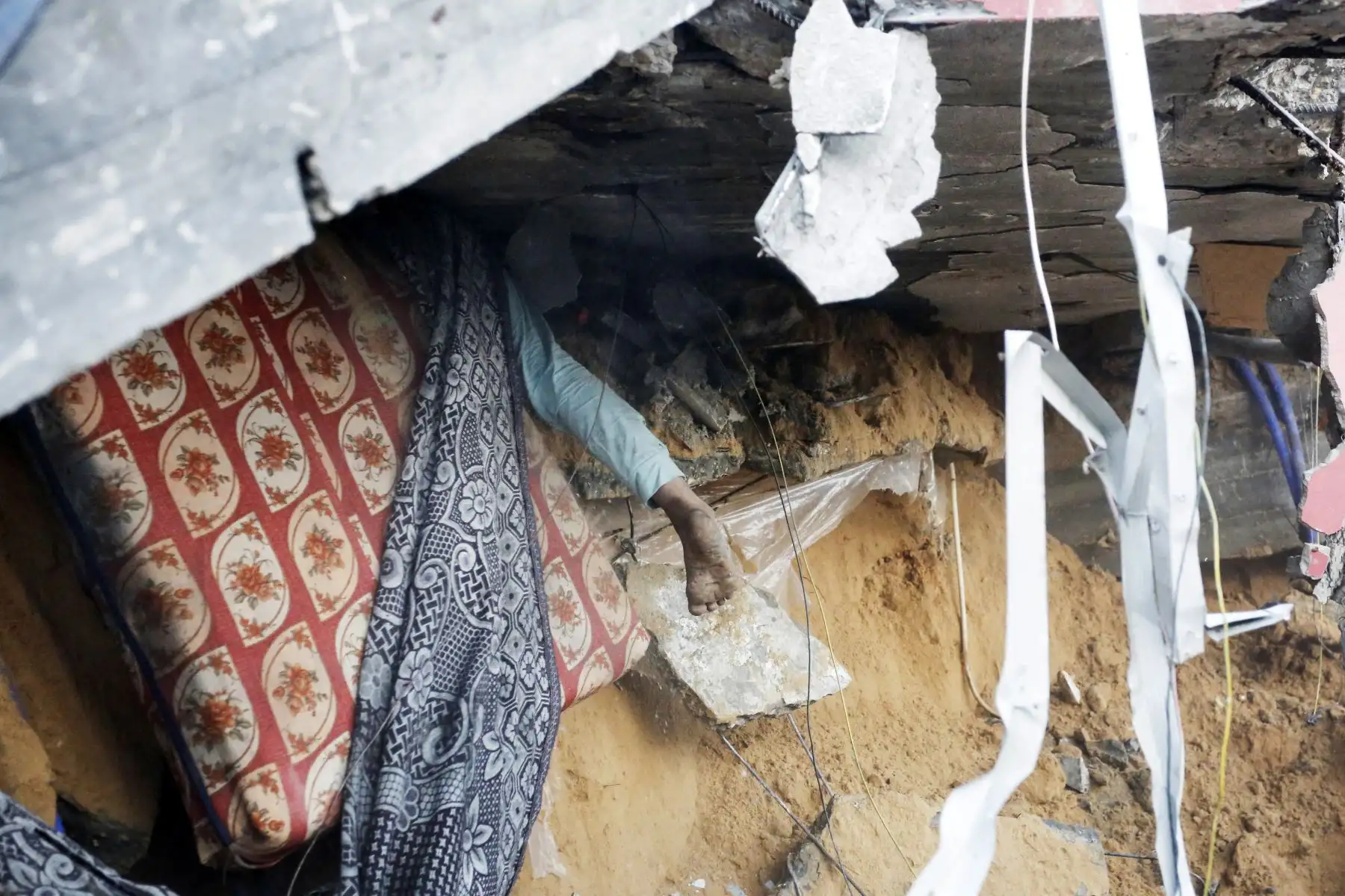 El pie de un joven palestino sobresale de debajo de los escombros de una casa tras un ataque israelí a la ciudad de Deir Al-Balah, en el centro de la Franja de Gaza, el 15 de octubre de 2023, en medio de las batallas en curso entre Israel y los islamistas palestinos. grupo Hamás. Miles de palestinos se han reunido en el sur de la Franja de Gaza, colocando camas en las calles después de que las escuelas administradas por la ONU se llenaran tras la advertencia de Israel de evacuar el norte del empobrecido enclave. Foto: AFP