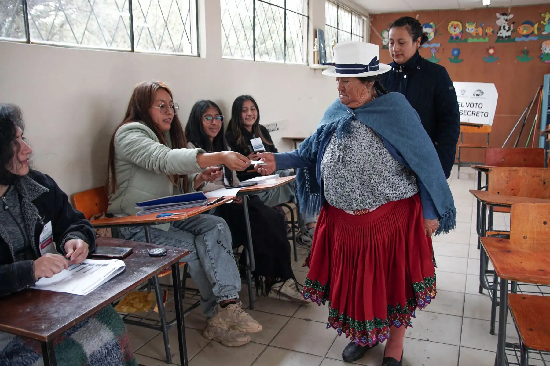 Una mujer indígena sale después de emitir su voto en un colegio electoral de la Unidad Educativa Fausto Molina en Tarqui, en las afueras de Cuenca, Ecuador, durante la segunda vuelta presidencial. Foto: ANDINA/AFP