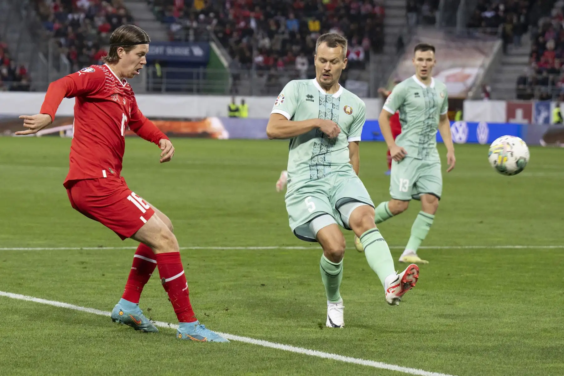El delantero suizo Cedric Itten  lucha por el balón con el defensor de Bielorrusia Denis Polyakov durante el partido de fútbol del grupo I de clasificación de la UEFA euro 2024 entre Suiza y Bielorrusia en el Kybunpark Estadio de St. Gallen (Suiza). Foto:ANDINA/ EFE