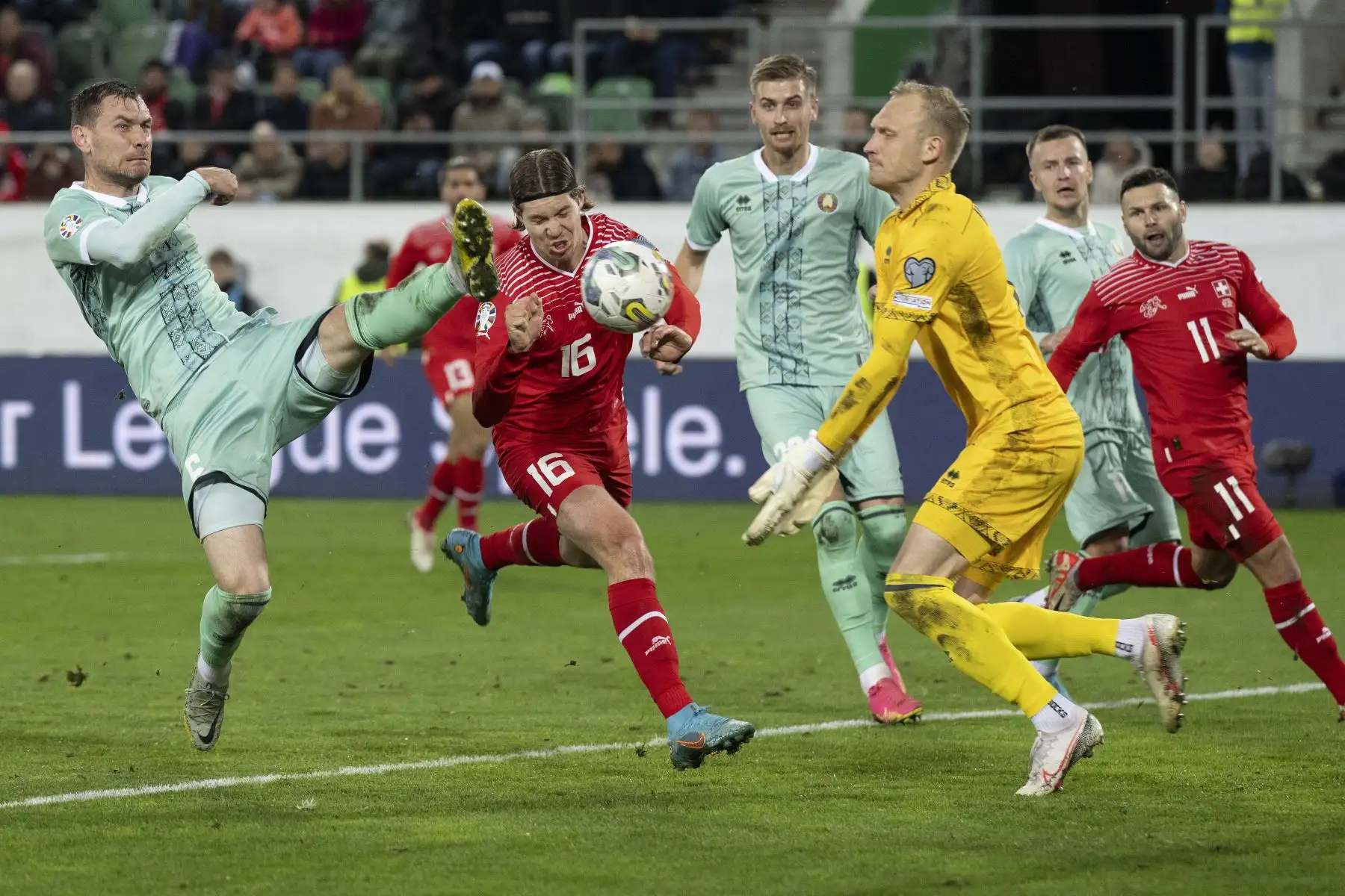 El delantero suizo Cedric Itten  lucha por el balón con el centrocampista bielorruso Sergei Politevich  y el portero bielorruso Sergei Ignatovich durante el grupo de clasificación de la UEFA euro 2024 I partido de fútbol entre Suiza y Bielorrusia en el estadio Kybunpark de St. Gallen. Foto: ANDINA/EFE