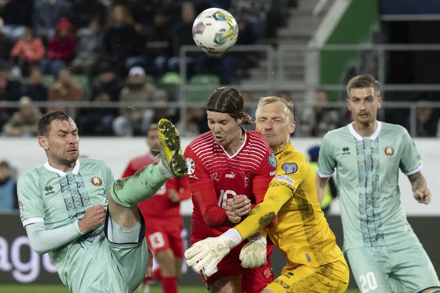El delantero suizo Cedric Itten  lucha por el balón con el centrocampista bielorruso Sergei Politevich y el portero bielorruso Sergei Ignatovich durante el grupo de clasificación de la UEFA euro 2024 I partido de fútbol entre Suiza y Bielorrusia en el estadio Kybunpark de St. Gallen. Foto: ANDINA/ EFE