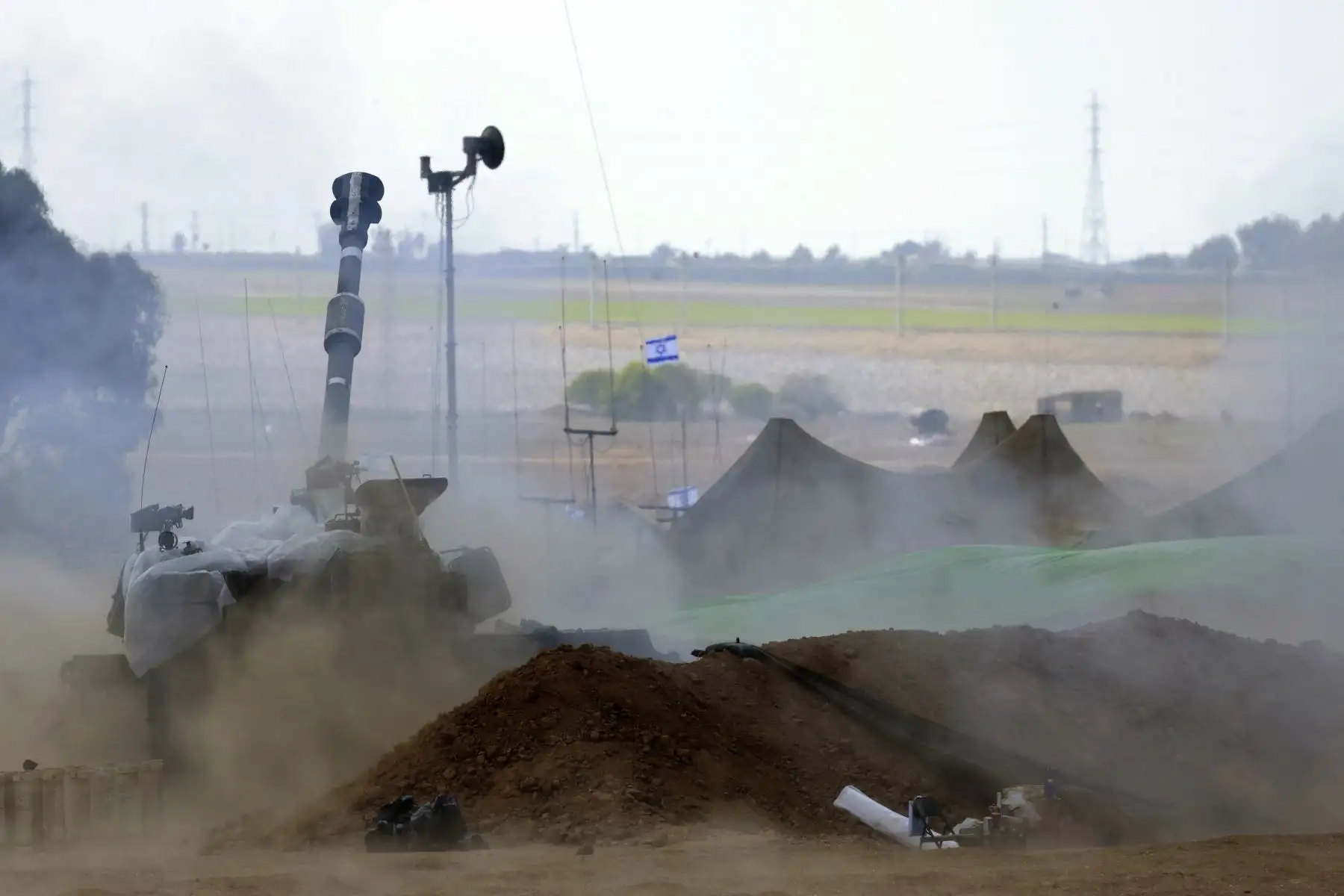 El polvo se levanta después de que un obús autopropulsado M109 de 155 mm dispara una bala desde cerca de la frontera israelí con Gaza en el sur de Israel.
Foto: AFP