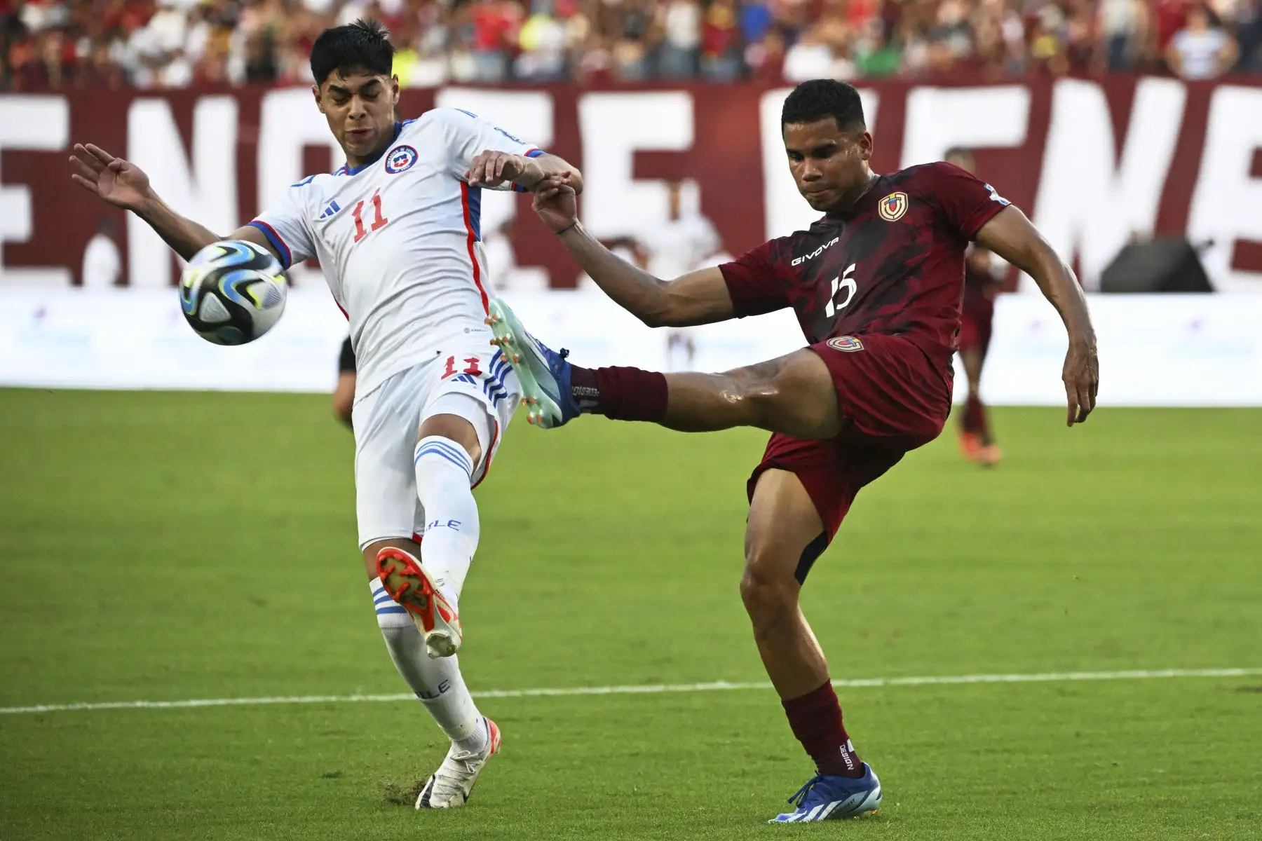 El mediocampista chileno Darío Osorio y el defensor venezolano Miguel Navarro luchan por el balón durante el partido de fútbol clasificatorio sudamericano para la Copa Mundial de la FIFA 2026 entre Venezuela y Chile en el Estadio Monumental de Maturín, Venezuela. Foto:ANDINA//AFP