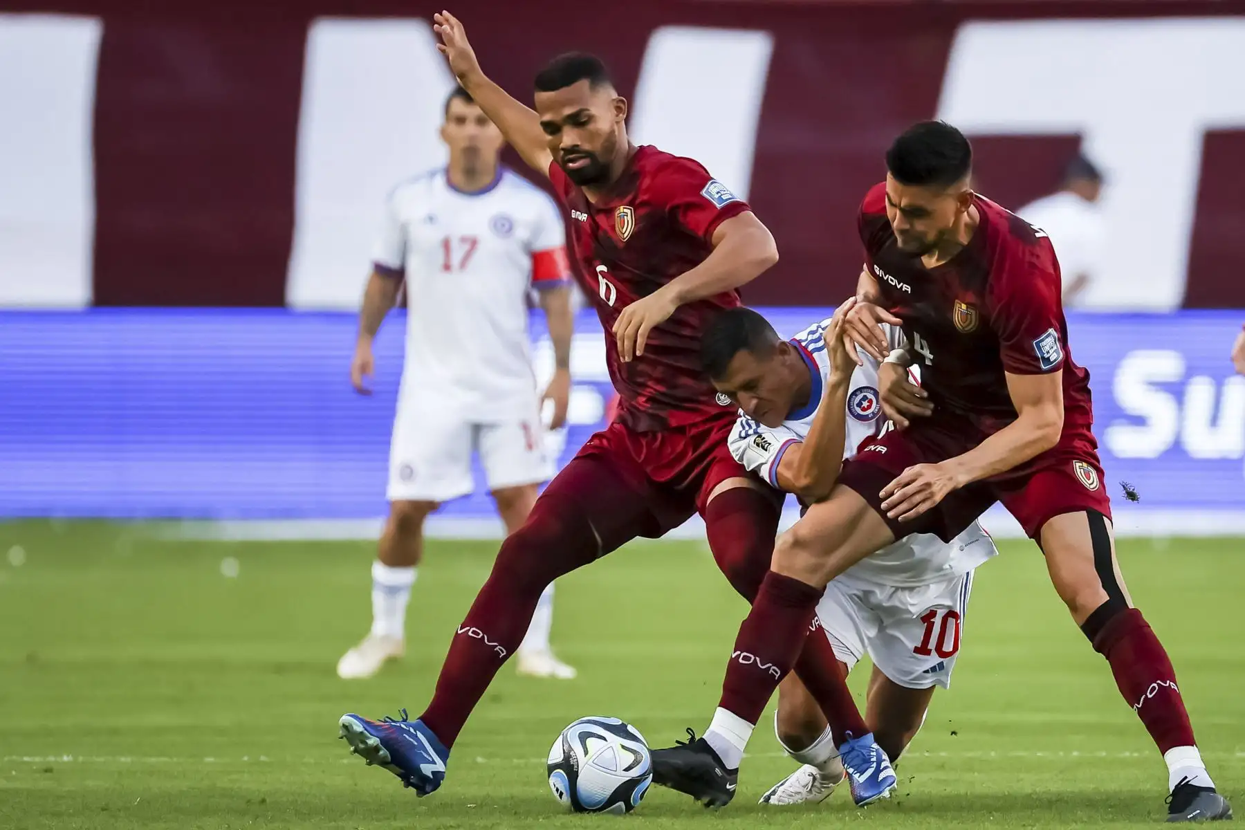 Yangel Herrera de Venezuela disputa el balón con Alexis Sánchez de Chile hoy, en un partido de las Eliminatorias Sudamericanas para la Copa Mundial de Fútbol 2026 entre Venezuela y Chile en el estadio Monumental de Maturín en Maturín (Venezuela). Foto:ANDINA/EFE