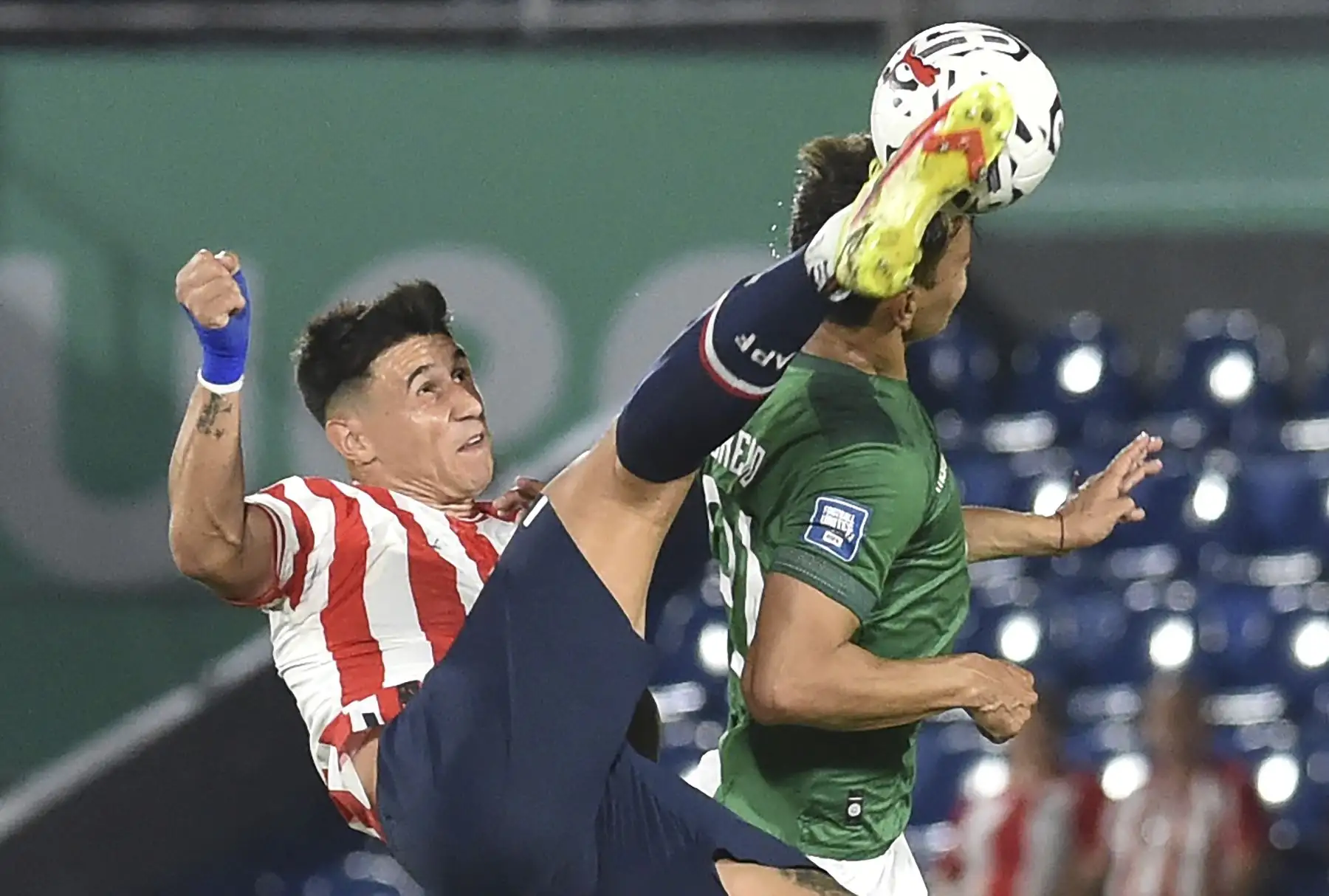 El delantero de Paraguay Adam Bareiro  y el defensor de Bolivia José Sagredo luchan por el balón durante el partido de fútbol de clasificación sudamericano para la Copa Mundial de la FIFA 2026 entre Paraguay y Bolivia en el estadio Defensores del Chaco en Asunción. Foto: ANDINA/AFP