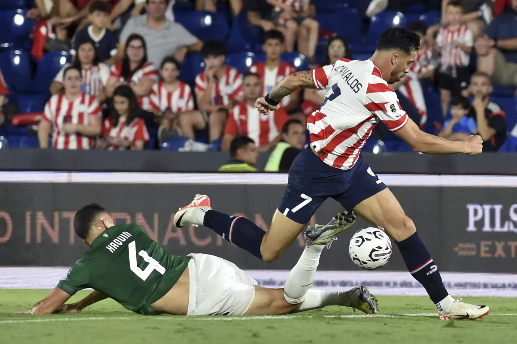 El defensor de Bolivia Luis Haquín  y el delantero de Paraguay Gabriel Ávalos  luchan por el balón durante el partido de fútbol de clasificación sudamericano para la Copa Mundial de la FIFA 2026 entre Paraguay y Bolivia en el estadio Defensores del Chaco en Asunción. Foto: ANDINA/AFP