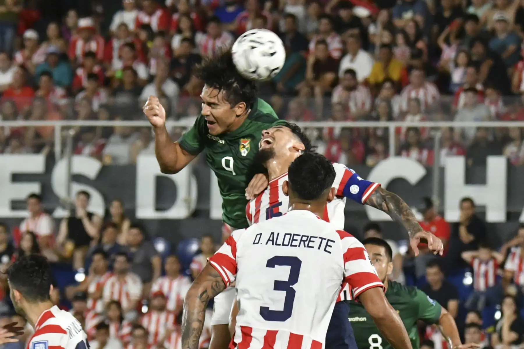 Gustavo Gómez de Paraguay disputa el balón con Marcelo Martins de Bolivia (arriba) hoy, en un partido de las Eliminatorias Sudamericanas para la Copa Mundial de Fútbol 2026 entre Paraguay y Bolivia en el estadio Defensores del Chaco en Asunción. Foto: ANDINA/EFE