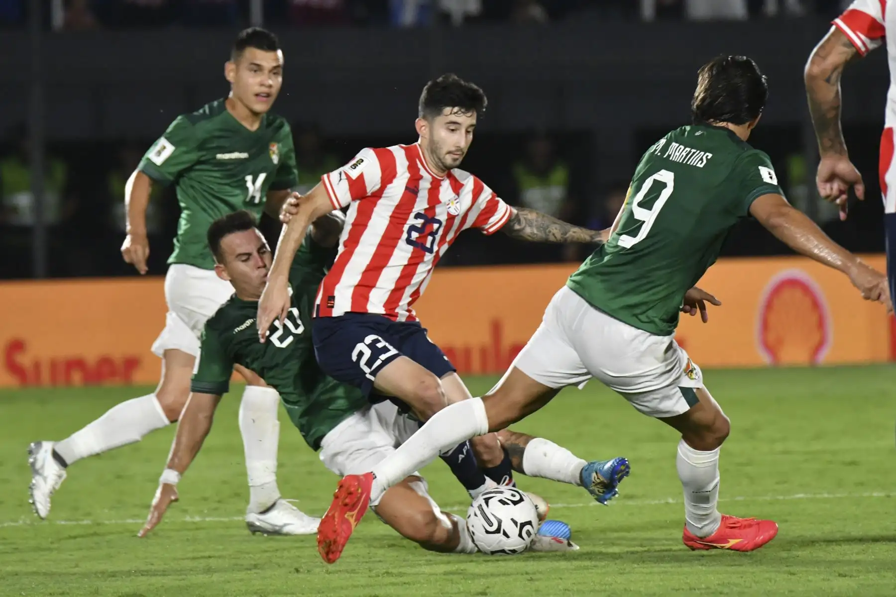 Mathías Villasanti de Paraguay disputa el balón con Henry Vaca y Marcelo Martins de Bolivia hoy, en un partido de las Eliminatorias Sudamericanas para la Copa Mundial de Fútbol 2026 entre Paraguay y Bolivia en el estadio Defensores del Chaco en Asunción.  Foto: ANDINAEFE