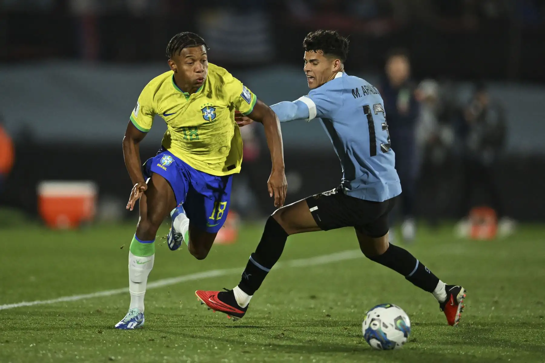 El delantero brasileño David Neres y el mediocampista uruguayo Maximiliano Araujo luchan por el balón durante el partido de fútbol de clasificación sudamericano para la Copa Mundial de la FIFA 2026 entre Uruguay y Brasil en el Estadio Centenario de Montevideo. Foto: AFP