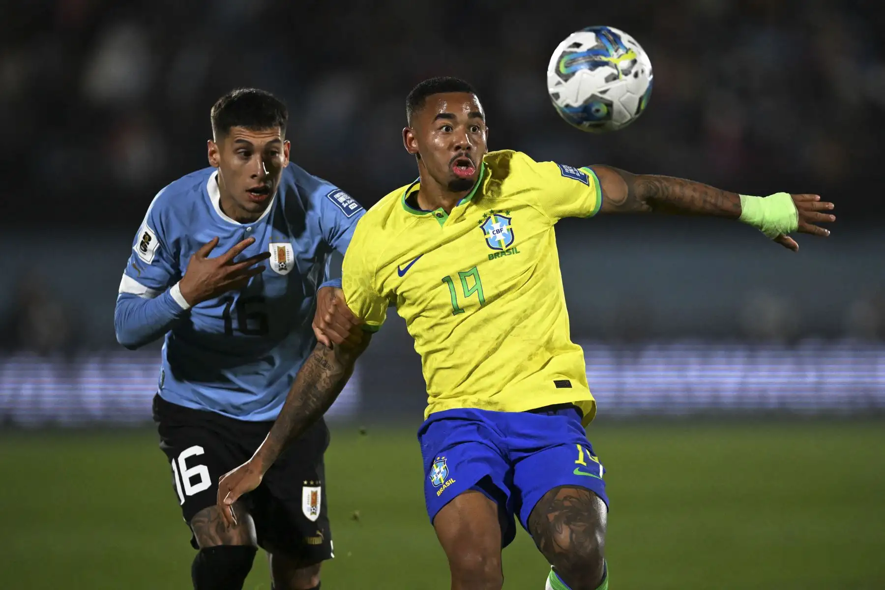 El defensor uruguayo Mathias Olivera y el delantero brasileño Gabriel Jesus luchan por el balón durante el partido de fútbol de clasificación sudamericano para la Copa Mundial de la FIFA 2026 entre Uruguay y Brasil en el Estadio Centenario de Montevideo. Foto: AFP