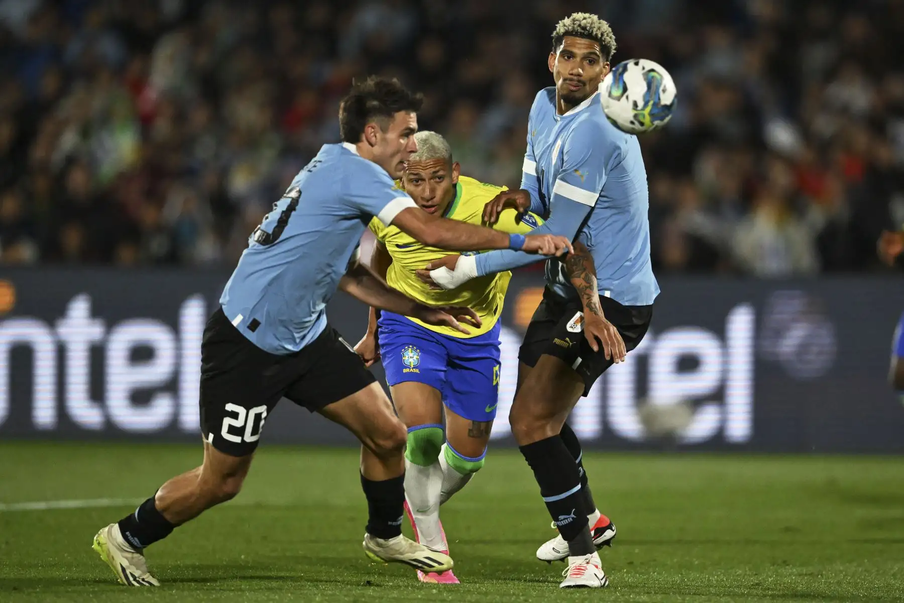 El delantero brasileño Richarlison lucha por el balón con el mediocampista uruguayo Manuel Ugarte y el defensor Ronald Araujo durante el partido de fútbol de clasificación sudamericano para la Copa Mundial de la FIFA 2026 entre Uruguay y Brasil en el Estadio Centenario de Montevideo. Foto: AFP