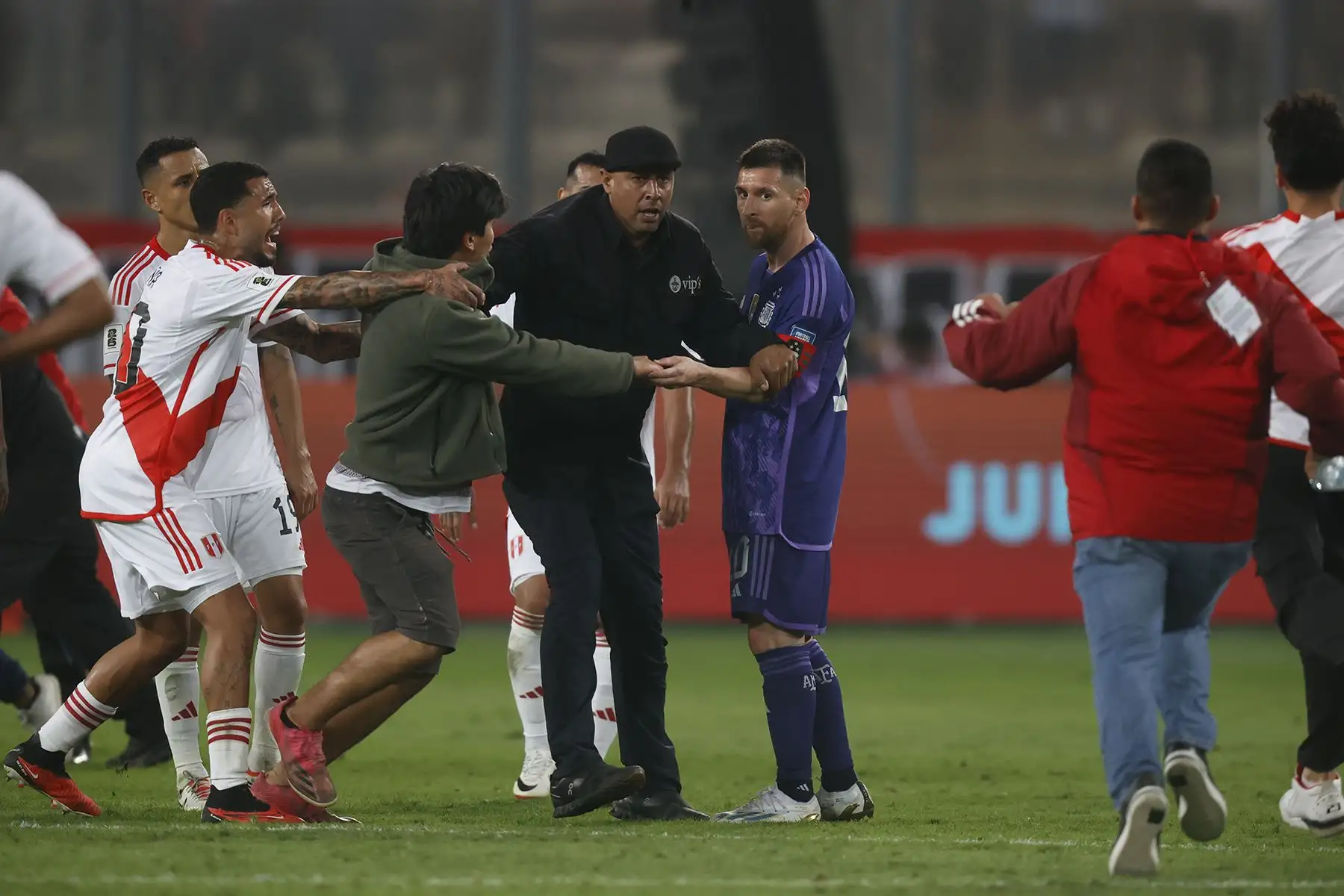 Hinchas  ingresan al campo de juego  con la intención de tomarse un fotografía con Lionel Messi poco antes del final del partido entre Perú y Argentina. La selección peruana cayó 2-0 en el Estadio Nacional. Foto: Andina / Carlos Lezama