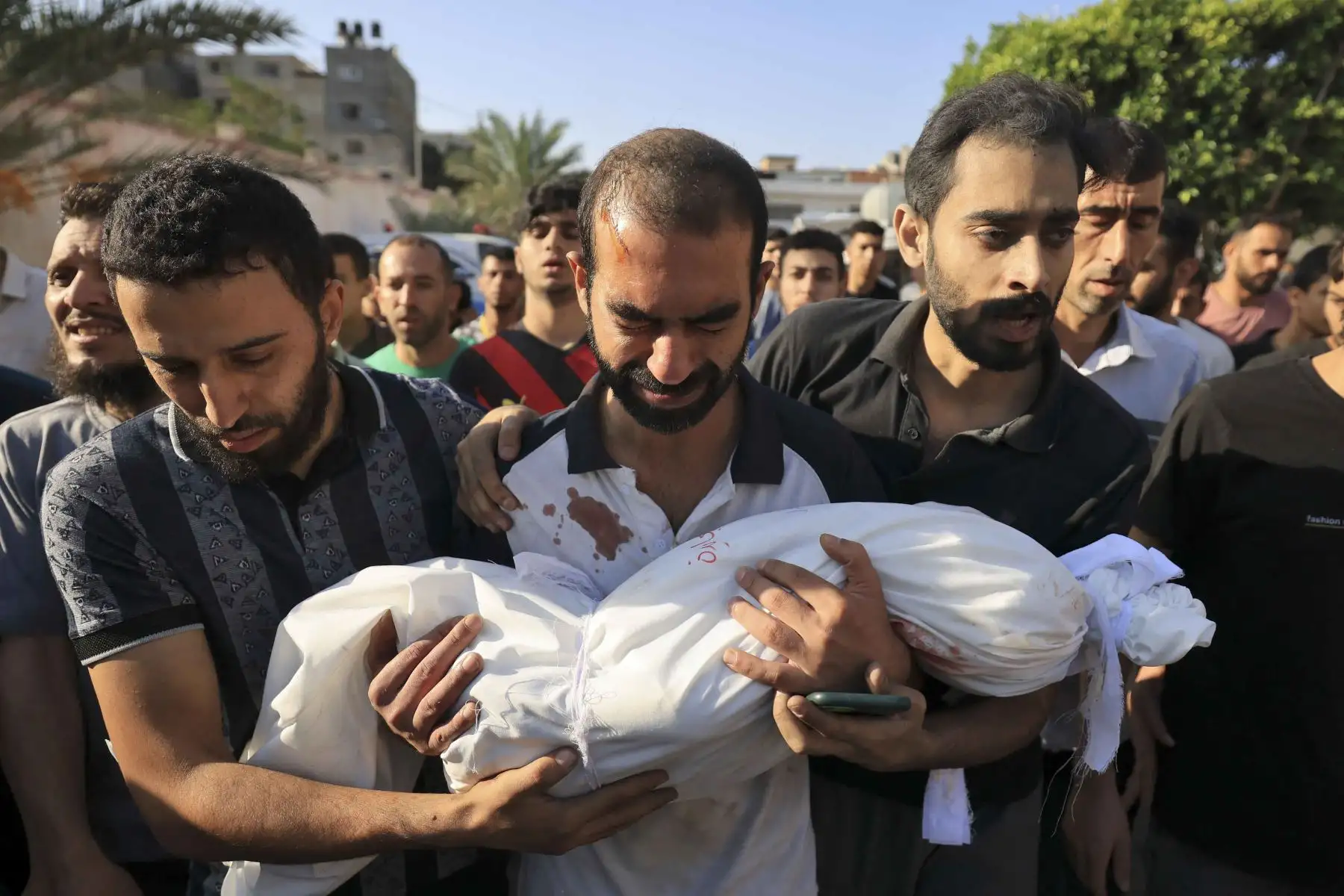 El padre de un niño de la familia al-Majaida que murió cuando un ataque aéreo israelí alcanzó su casa lleva su cuerpo durante su funeral en Khan Yunis, en el sur de la Franja de Gaza. Foto: AFP