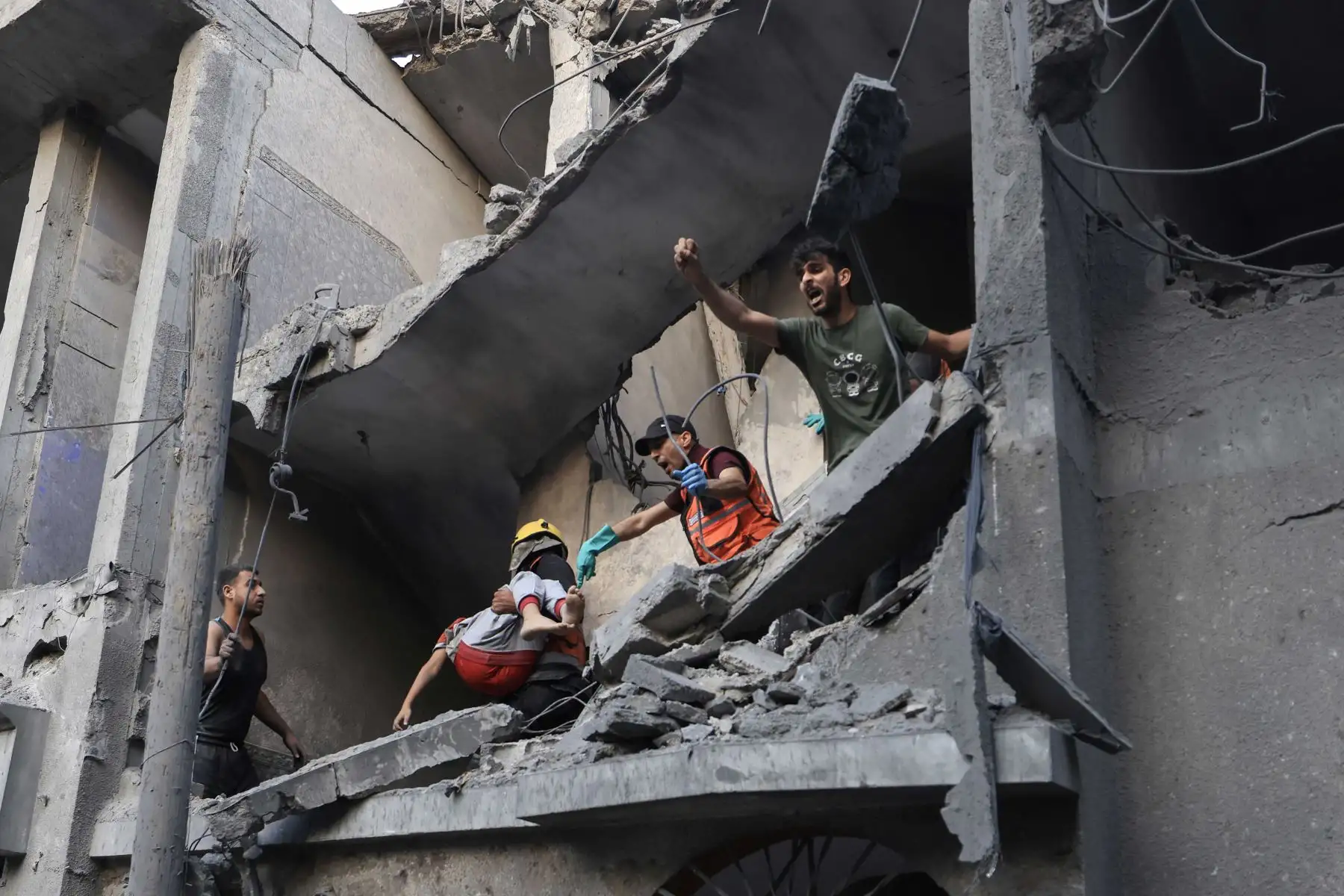 Miembros de la defensa civil palestina y otras personas llevan a un niño muerto en un bombardeo israelí desde un edificio en Khan Yunis, en el sur de la Franja de Gaza. Foto: AFP