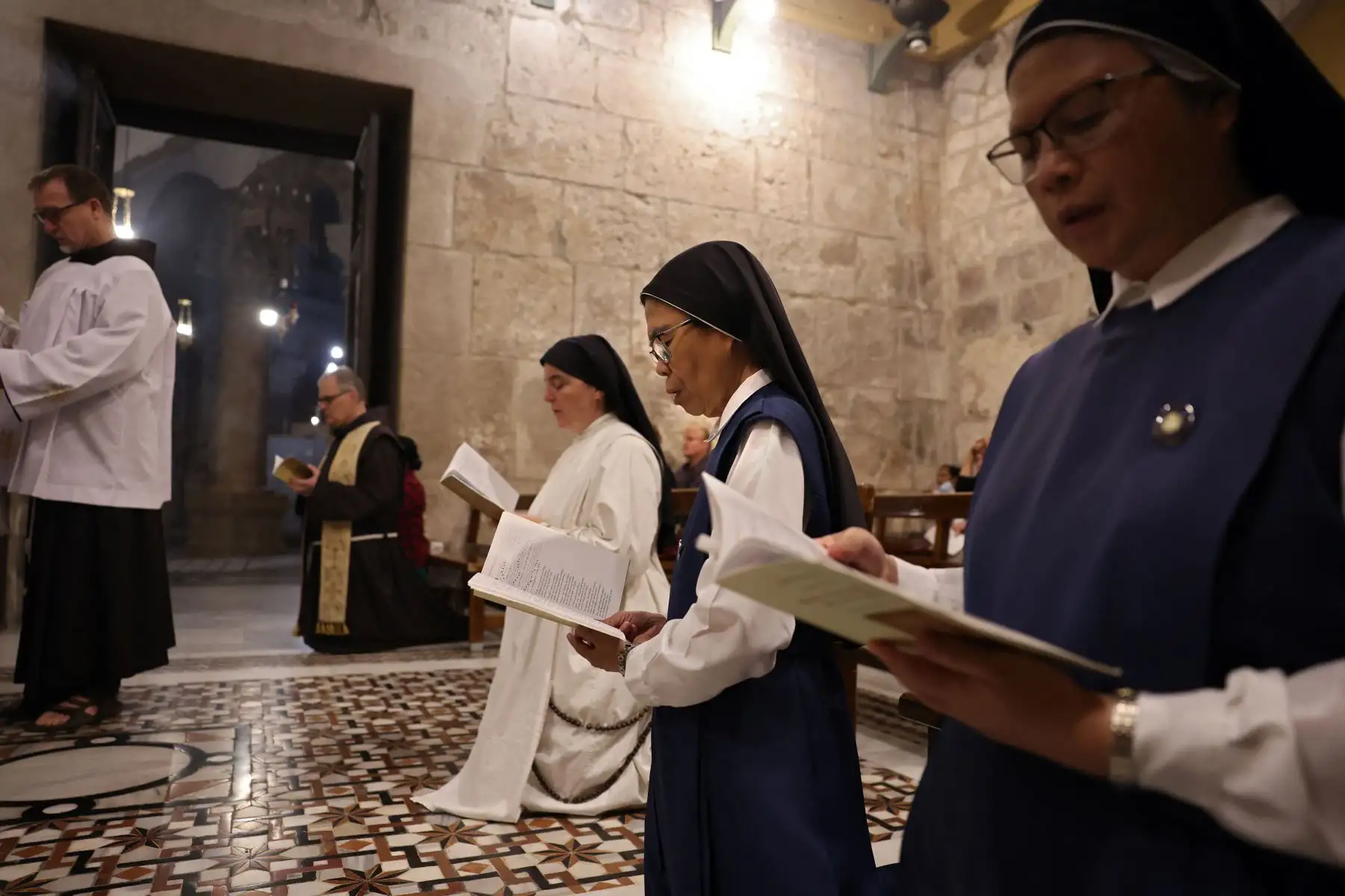 Frailes franciscanos y fieles rezan durante una procesión dedicada a la paz en Israel y Gaza, en la Iglesia del Santo Sepulcro en la Ciudad Vieja de Jerusalén.
Foto: AFP