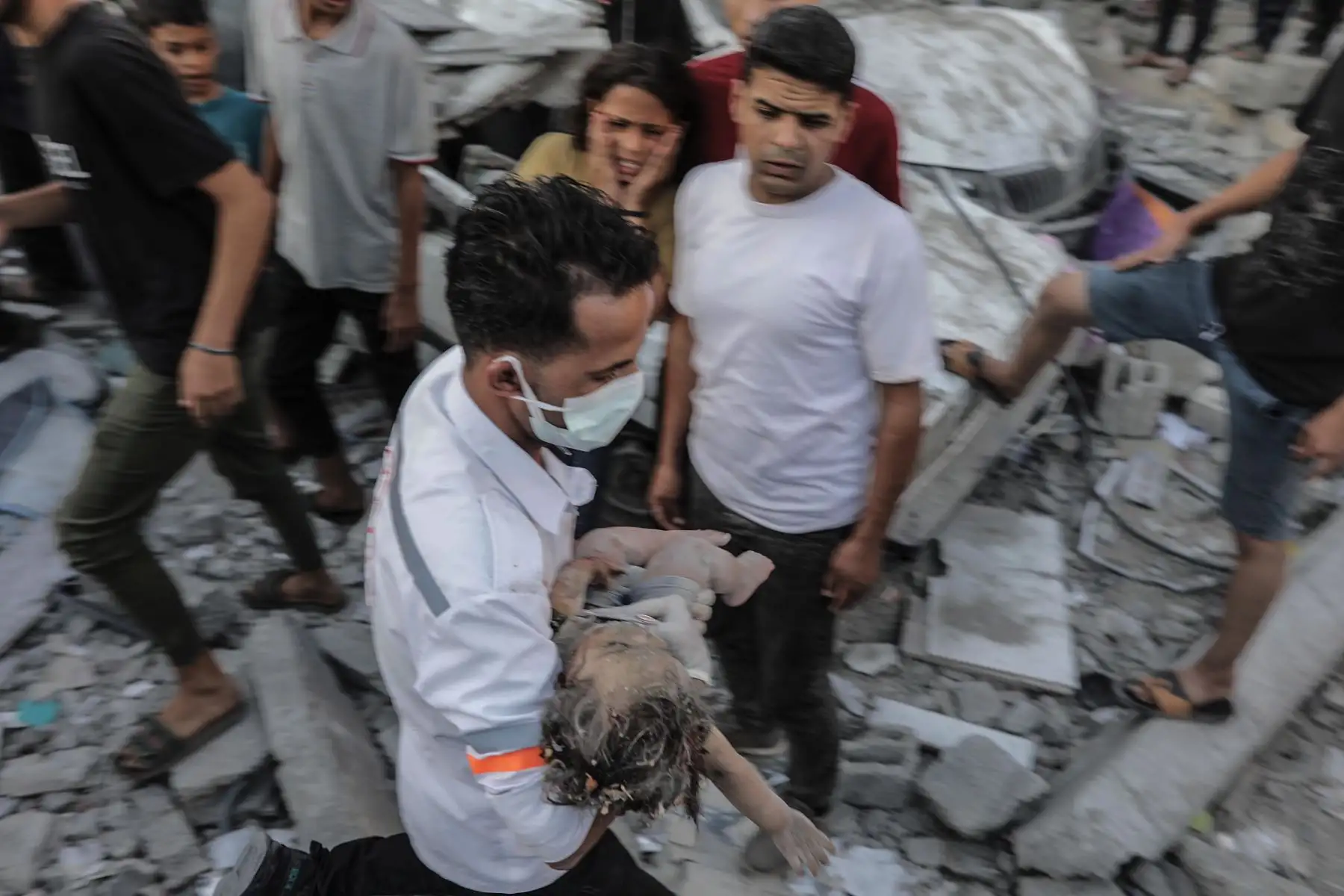 Un hombre carga a un niño entre los escombros de un edificio residencial derribado por un ataque aéreo, en el campo de refugiados de Khan Younis, en el sur de la Franja de Gaza.
Foto: AFP