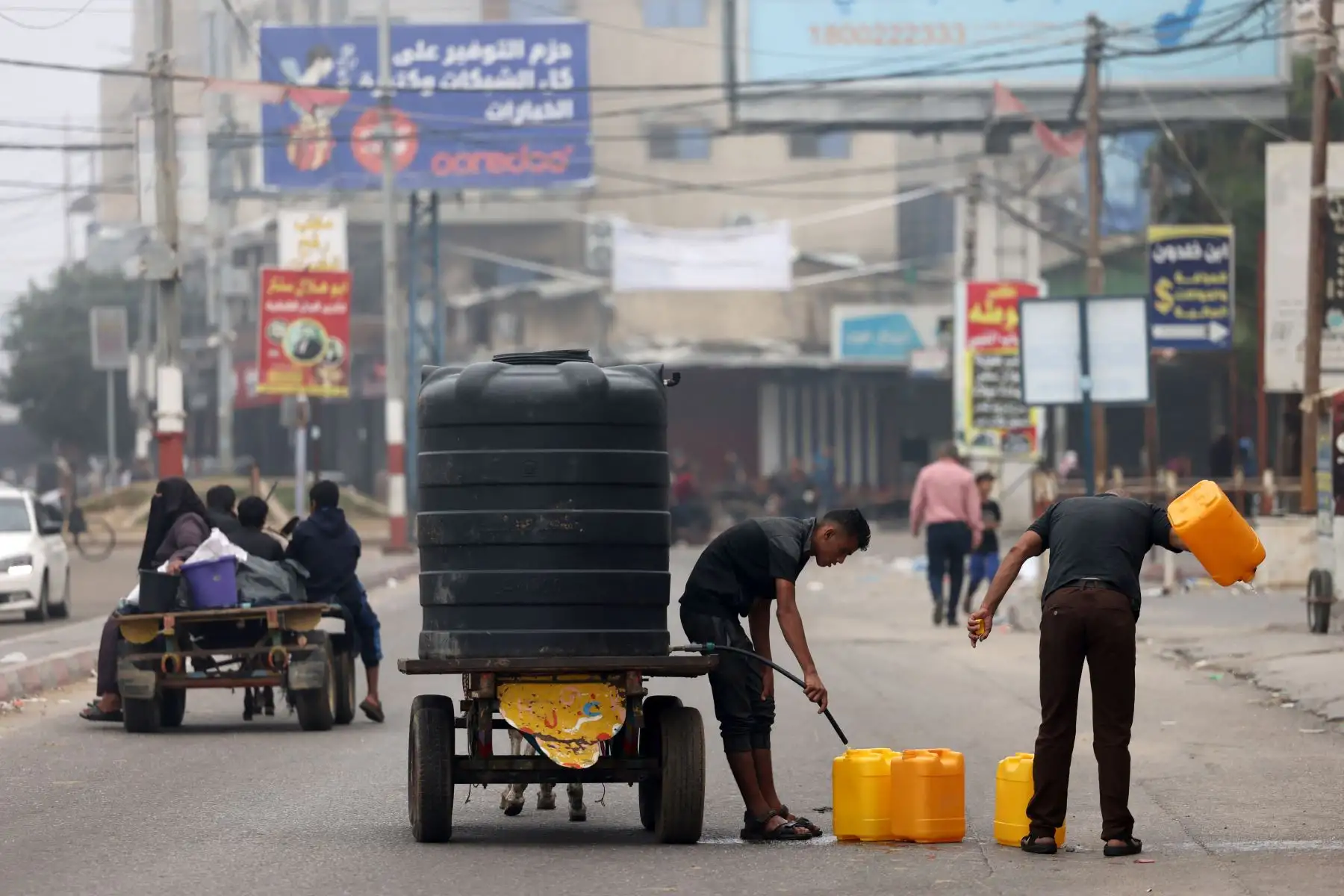 Hombres llenan bidones de plástico con agua portátil en Rafah, en el sur de la Franja de Gaza, en medio de las batallas en curso entre Israel y el grupo palestino Hamás. 
Foto: AFP