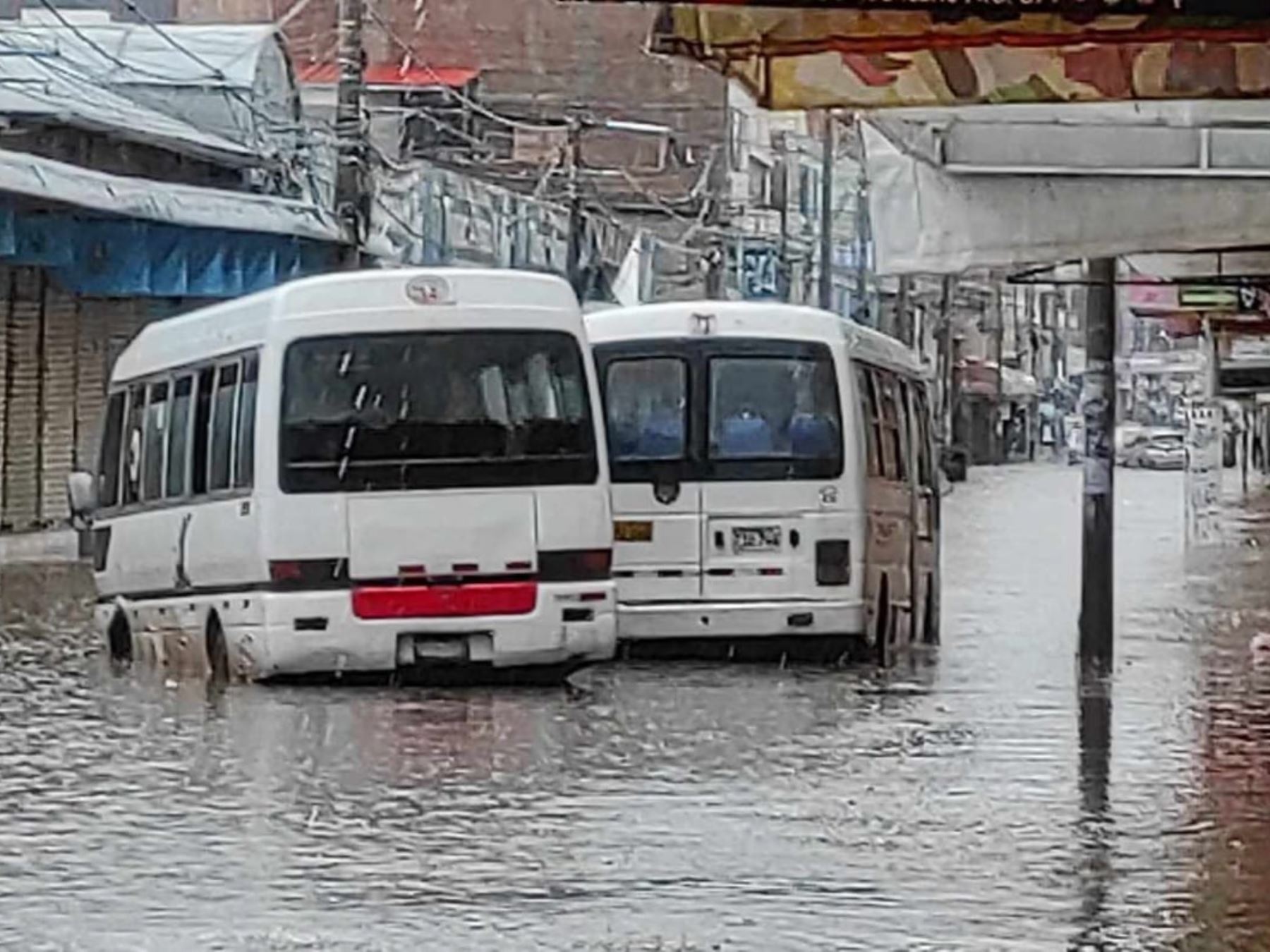 Dos vehículos de transporte público quedaron atrapados por los aniegos generados por las lluvias intensas registradas hoy en Juliaca. ANDINA/Difusión