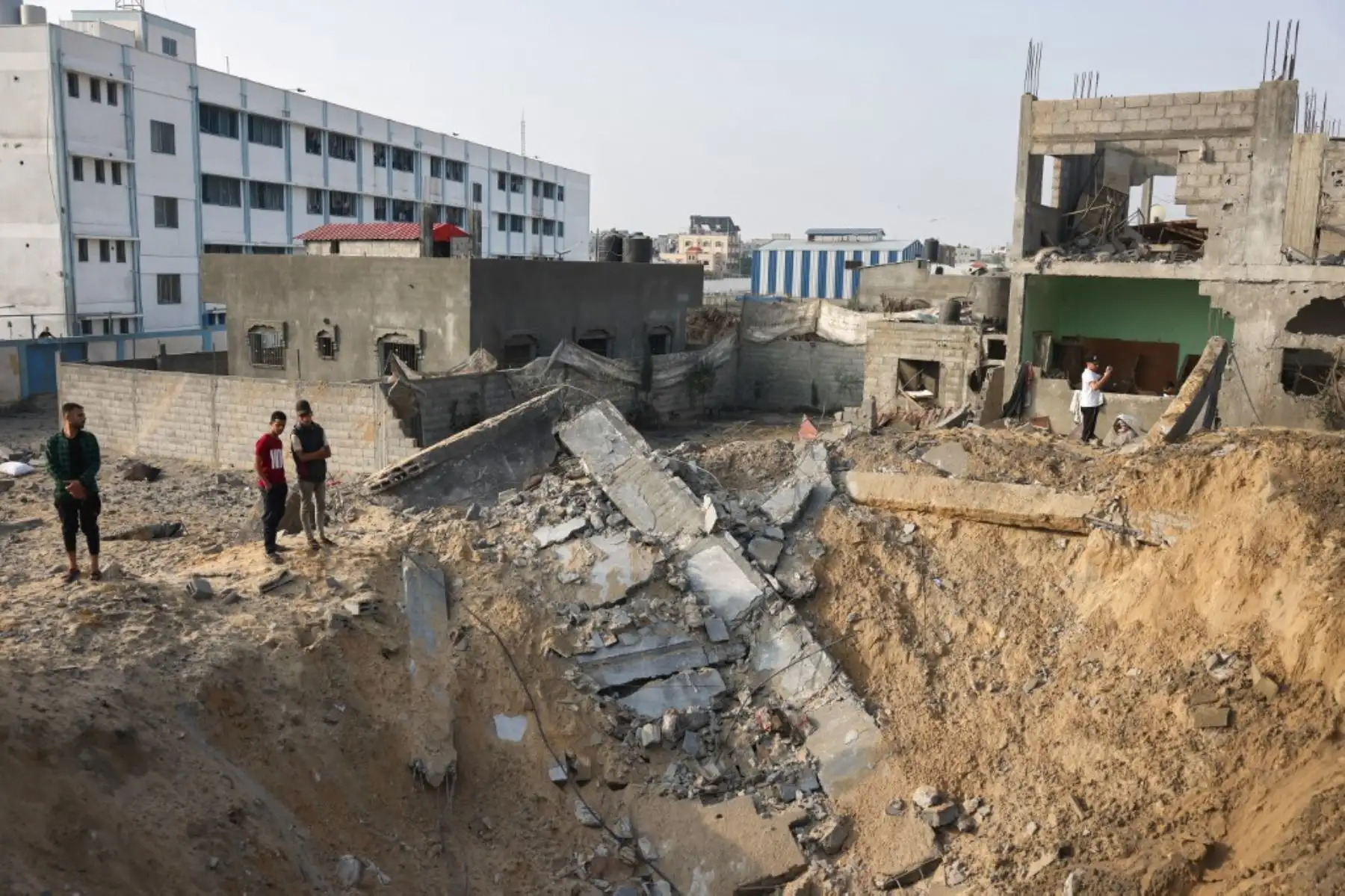 La gente se encuentra alrededor de un cráter tras los ataques israelíes contra Rafah, en el sur de la Franja de Gaza. Foto: AFP