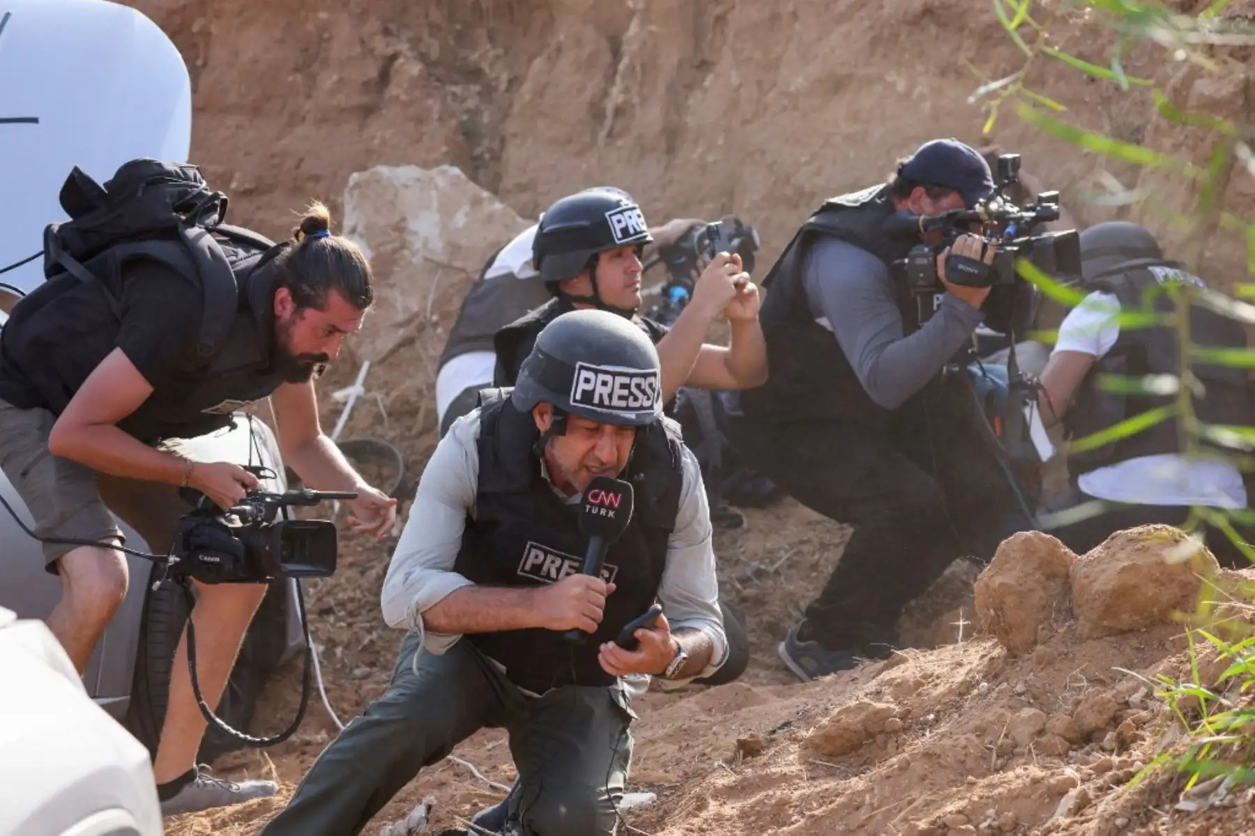 Los reporteros se refugian al escuchar sirenas que advierten de un ataque con cohetes desde Gaza, en la ciudad de Sderot, en el sur de Israel. Foto: AFP