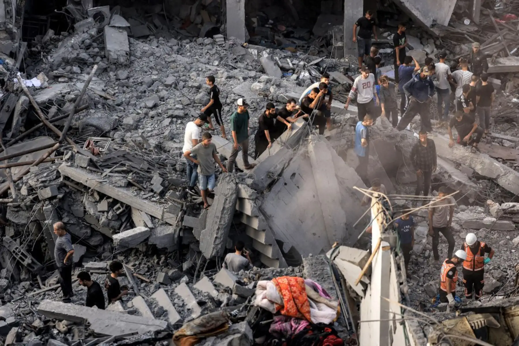 Palestinos observan los esfuerzos de rescate entre los escombros de un edificio tras los ataques israelíes nocturnos contra el campo de refugiados de Rafah, en el sur de la Franja de Gaza. Foto: AFP
