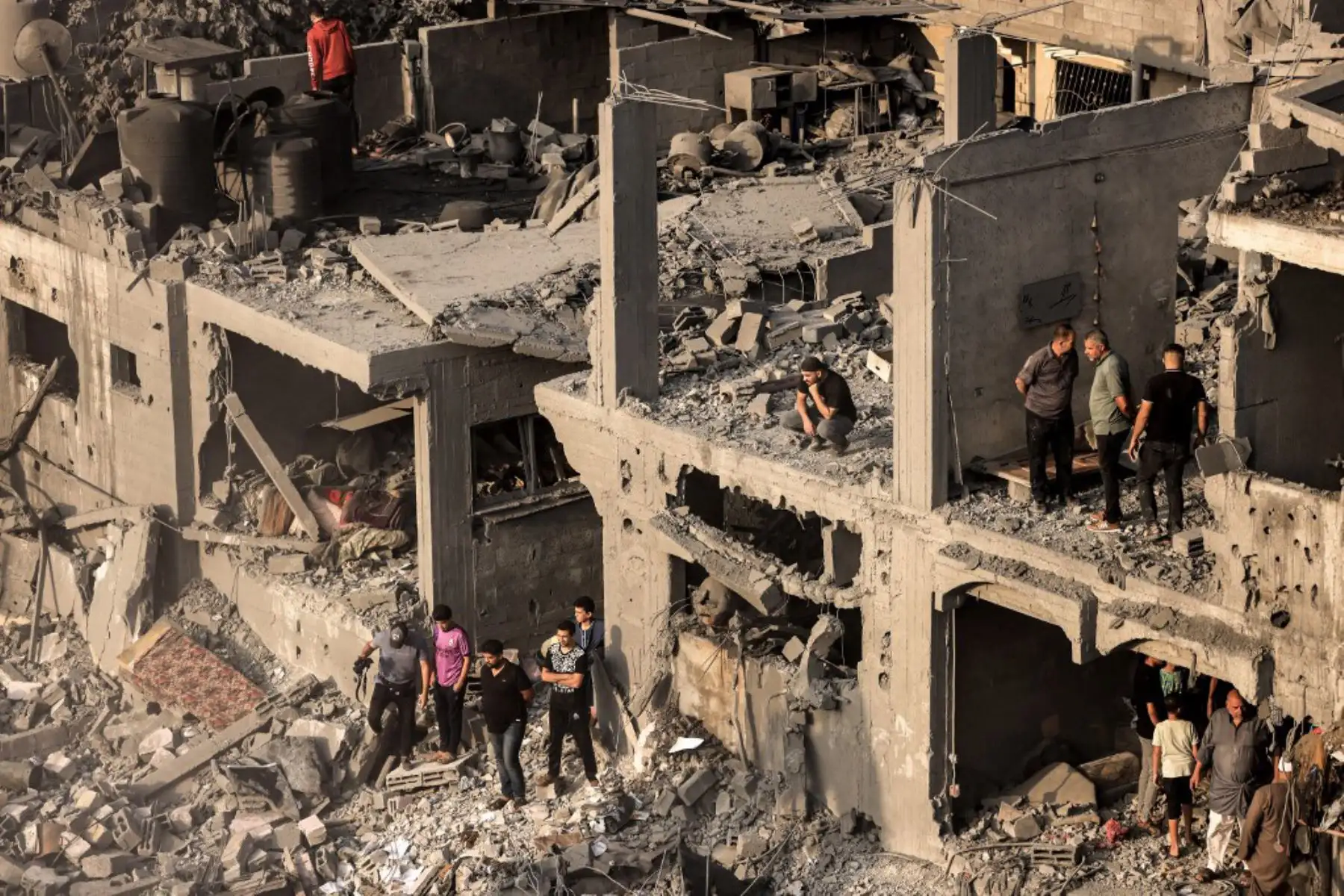 Palestinos buscan supervivientes y los cuerpos de las víctimas a través de edificios destruidos durante el bombardeo israelí, en Khan Yunis, en el sur de la Franja de Gaza. Foto: AFP