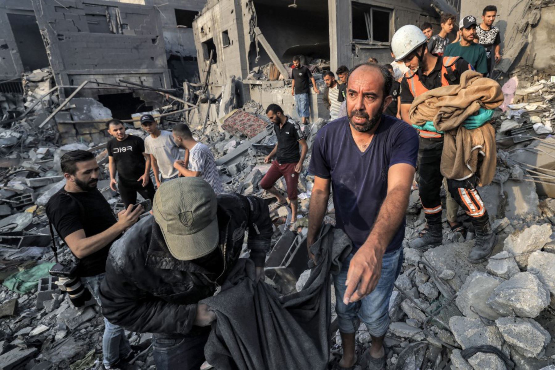Palestinos buscan supervivientes entre los escombros de edificios destruidos por un bombardeo israelí, en Khan Yunis, sur de la Franja de Gaza. Foto: AFP
