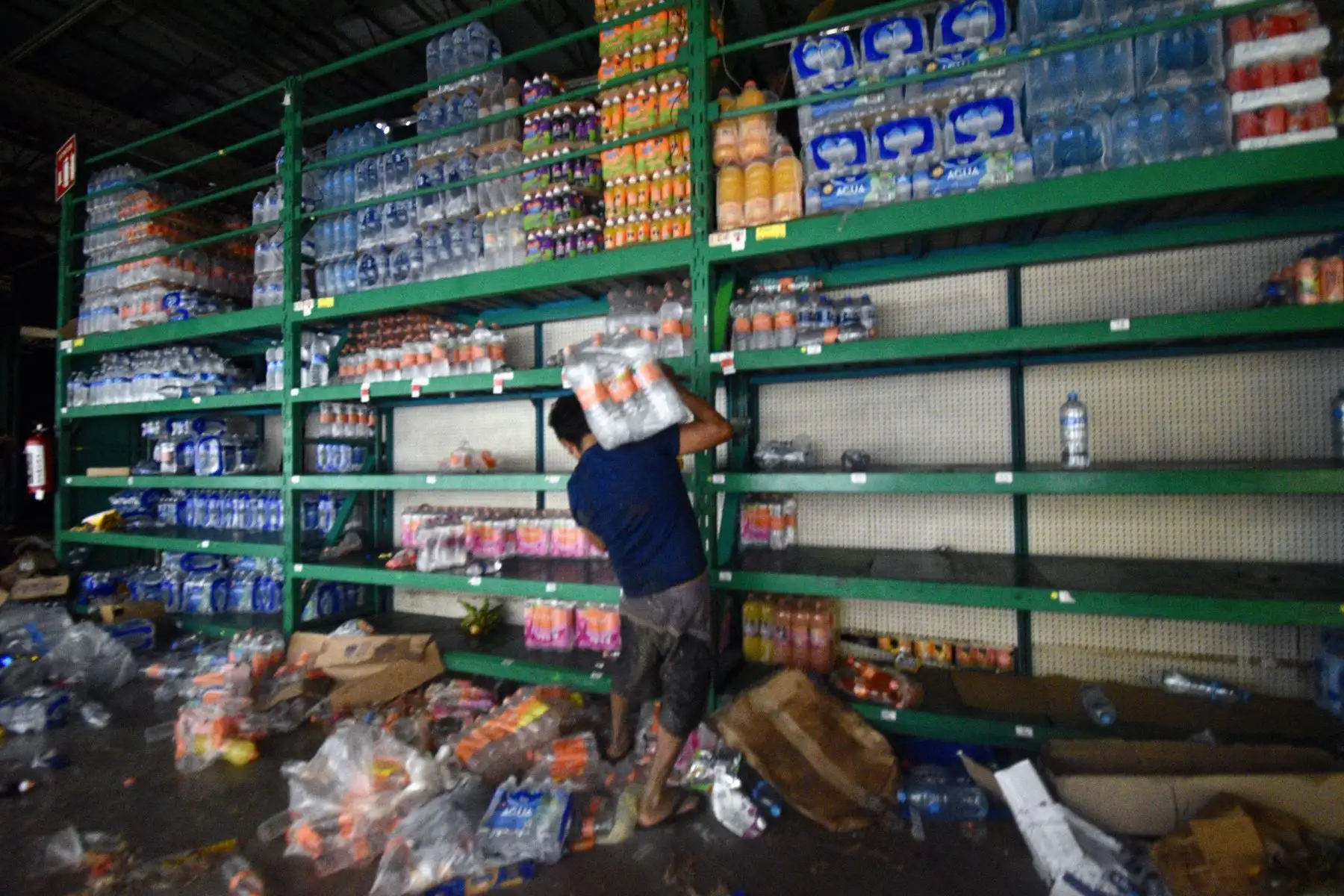 Un hombre recoge comestibles en un supermercado saqueado después del paso del huracán Otis en Acapulco, estado de Guerrero, México, el 25 de octubre de 2023.
Foto: AFP