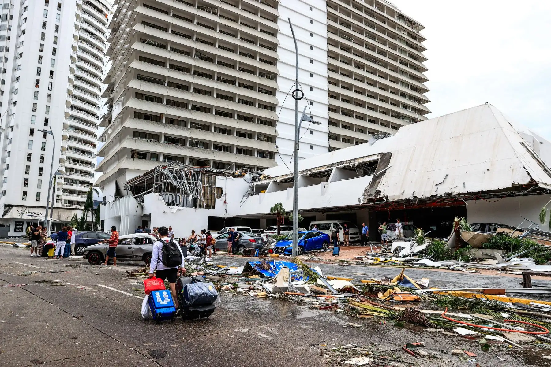 Vecinos caminan entre los escombros en una calle afectada por el huracán Otis, hoy, en el balneario de Acapulco, en el estado de Guerrero (México). El primer reporte de víctimas tras el paso del huracán Otis por la costa sur del estado de Guerrero da cuenta de 27 personas fallecidas y 4 desaparecidas. 
Foto: EFE