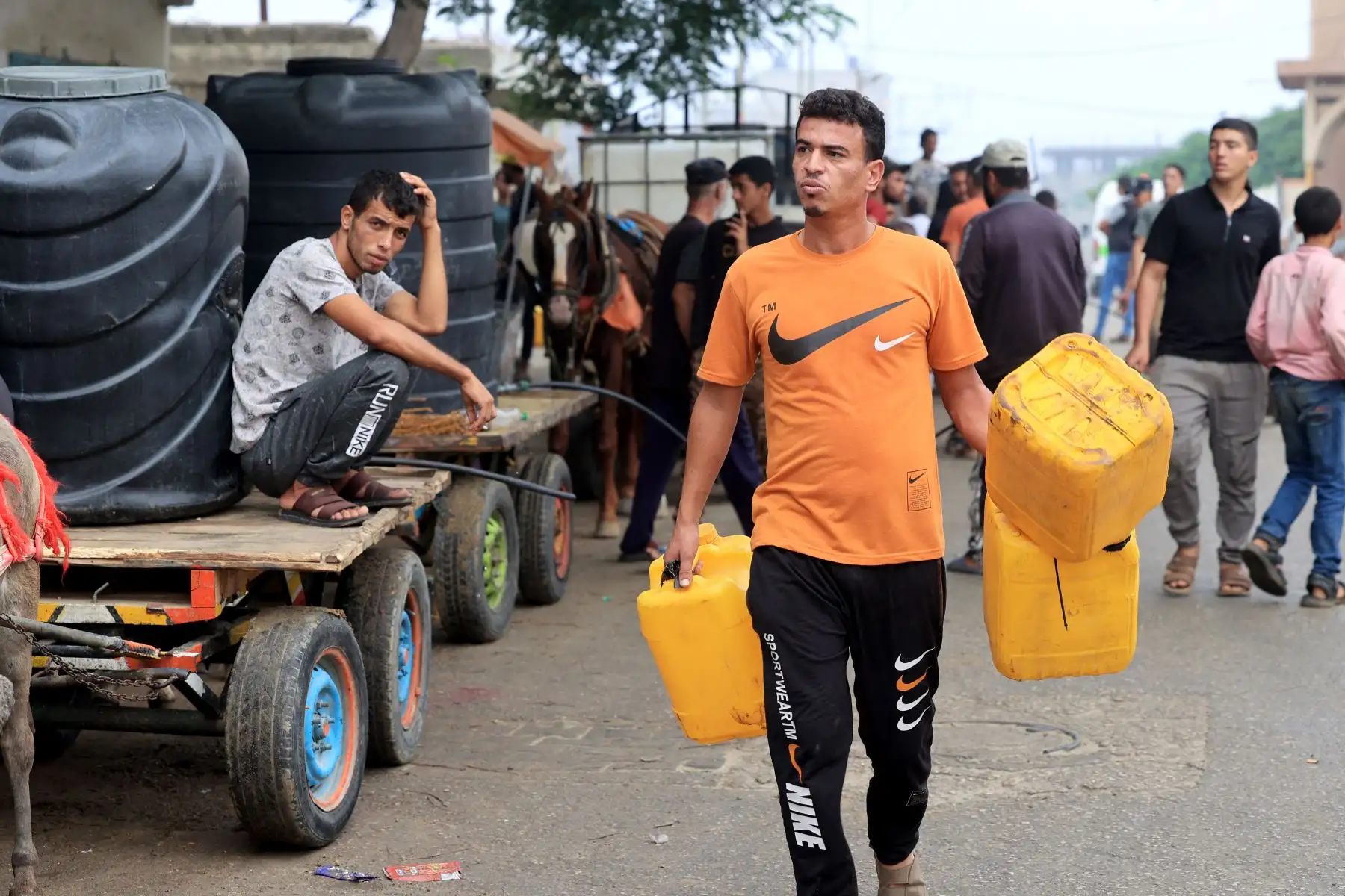 Civiles palestinos esperan para recoger agua en carros tirados por caballos y burros, en Rafah, en el sur de la Franja de Gaza,  en medio de las batallas en curso entre Israel y el grupo palestino Hamás. Miles de civiles, tanto palestinos como israelíes, después de que militantes palestinos de Hamás con base en la Franja de Gaza ingresaran al sur de Israel en un ataque sin precedentes que desencadenó una guerra declarada por Israel a Hamás con bombardeos de represalia en Gaza. Foto. ANDINA/AFP