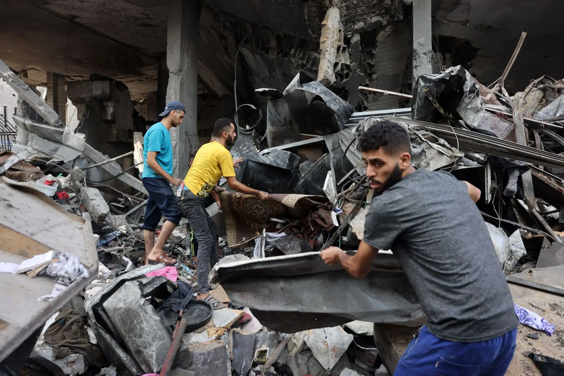 La gente revisa los escombros de un edificio destruido tras los ataques israelíes contra el campamento de Al-Shatee en la ciudad de Gaza, Los ataques aéreos israelíes destruyeron cientos de edificios en la Franja de Gaza durante la noche, informó el servicio de defensa civil en el territorio palestino controlado por Hamas. Foto: ANDINA/AFP