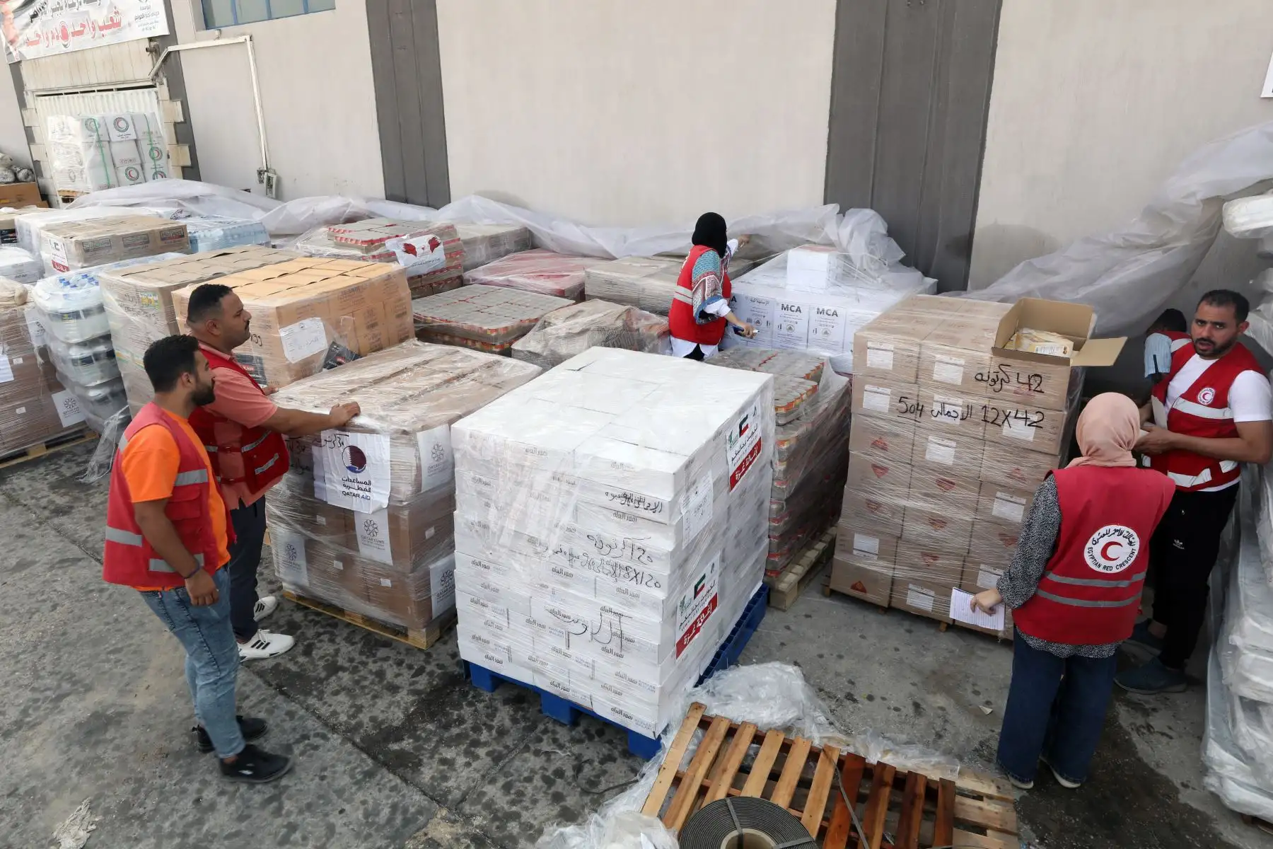 Empleados de la Sociedad de la Media Luna Roja Egipcia manejan ayuda humanitaria con destino a los palestinos en la Franja de Gaza, en un almacén en Arish, Egipto, Más de 7.000 palestinos y al menos 1.300 israelíes han han muerto, según las Fuerzas de Defensa de Israel (FDI) y las autoridades sanitarias palestinas, desde que militantes de Hamás lanzaron un ataque contra Israel. Foto: ANDINA/ EFE